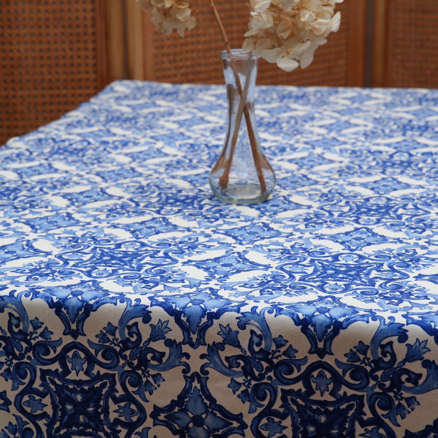 Blue and white ornamental tablecloth draped over the table edge, highlighting the bold pattern and clean hem