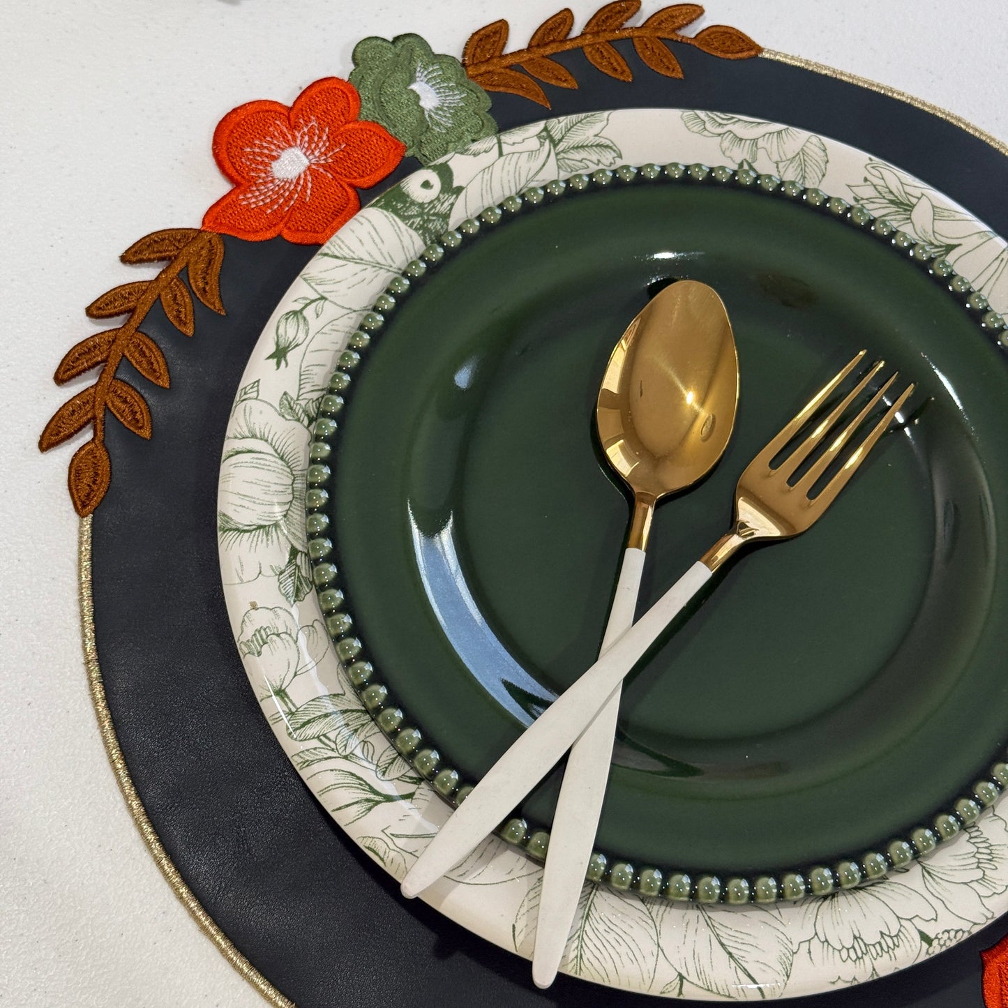 Jasmine Dark Green Round Faux Leather Placemat – close-up view showing the intricate embroidery, double-layer stitching, and premium vegan faux leather texture. Exclusively by PNR Decor.