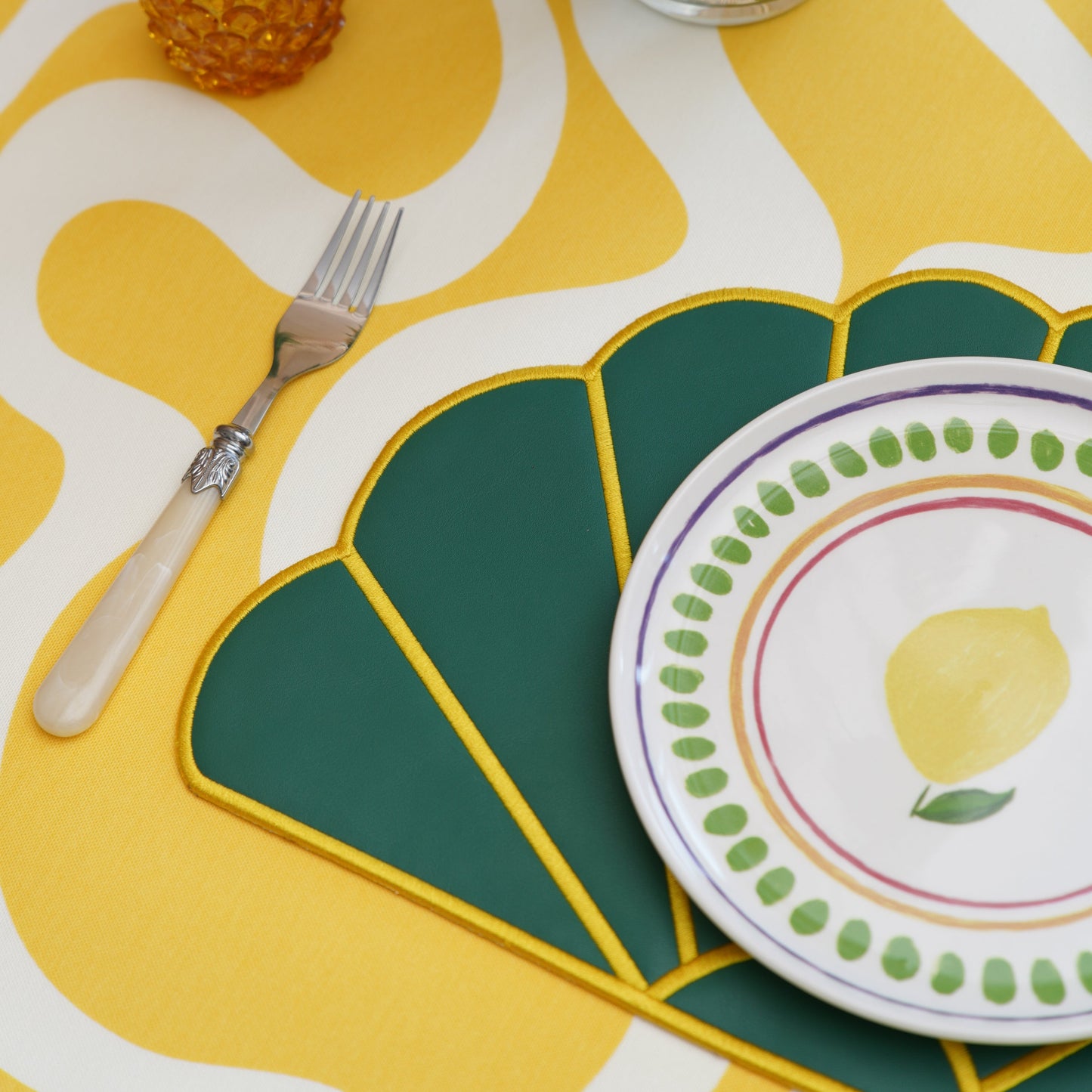 Top-down view of a layered faux leather placemat arranged for dining