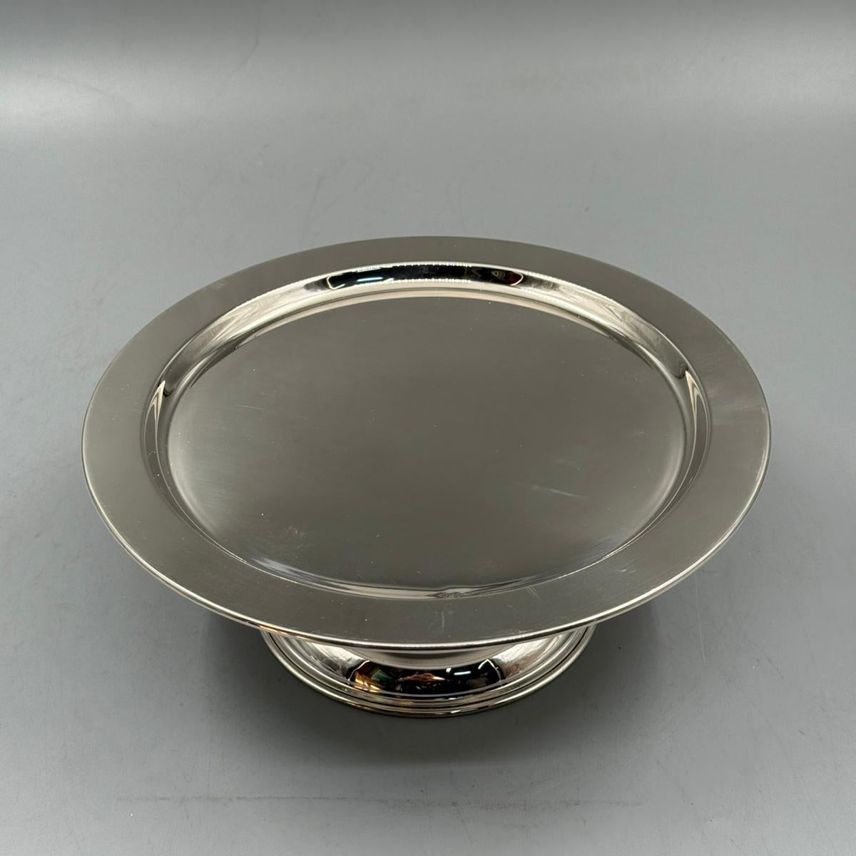 Elegant elevated silver cake stand with round base, perfect for desserts and pastries