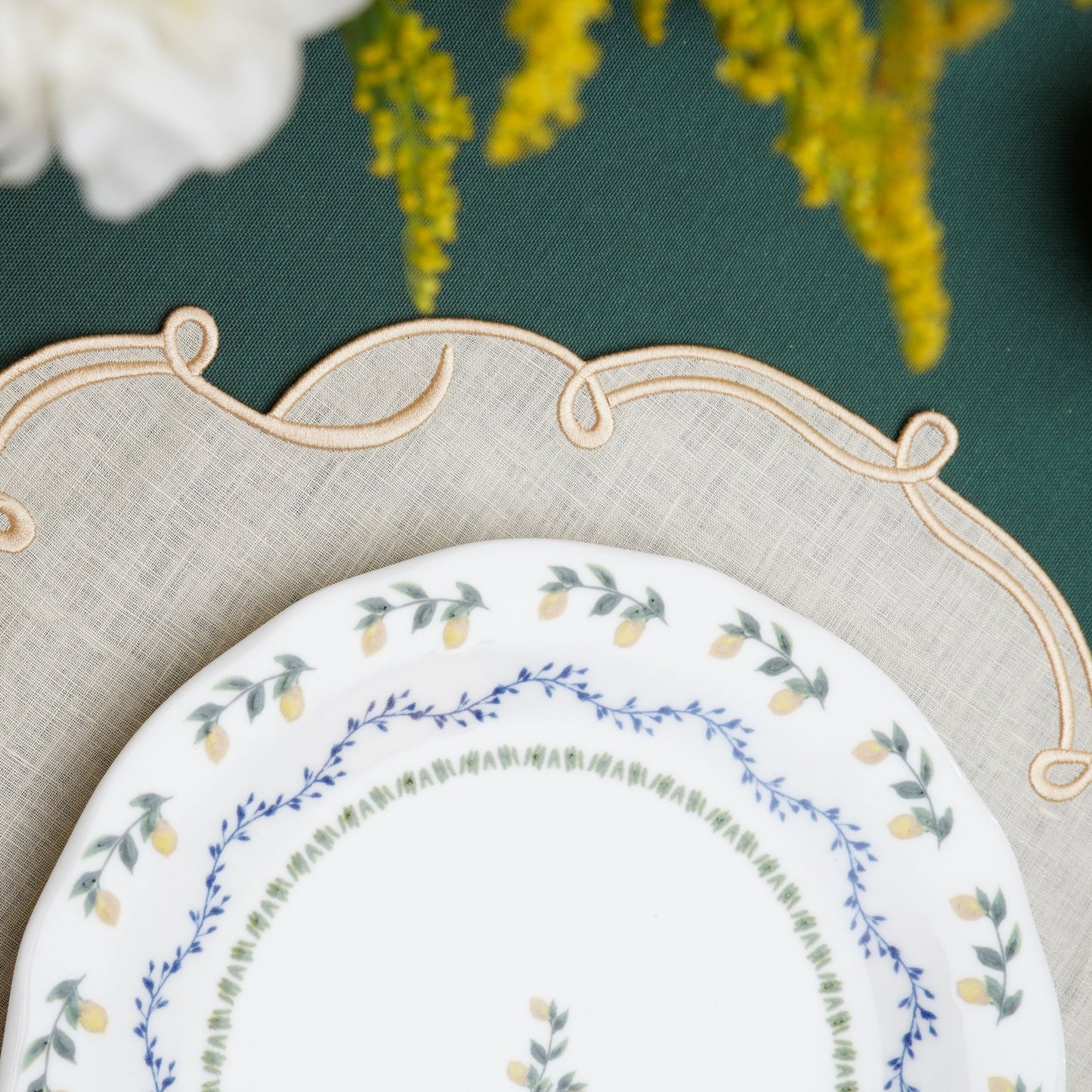 Square ivory linen placemat designed with refined gold border