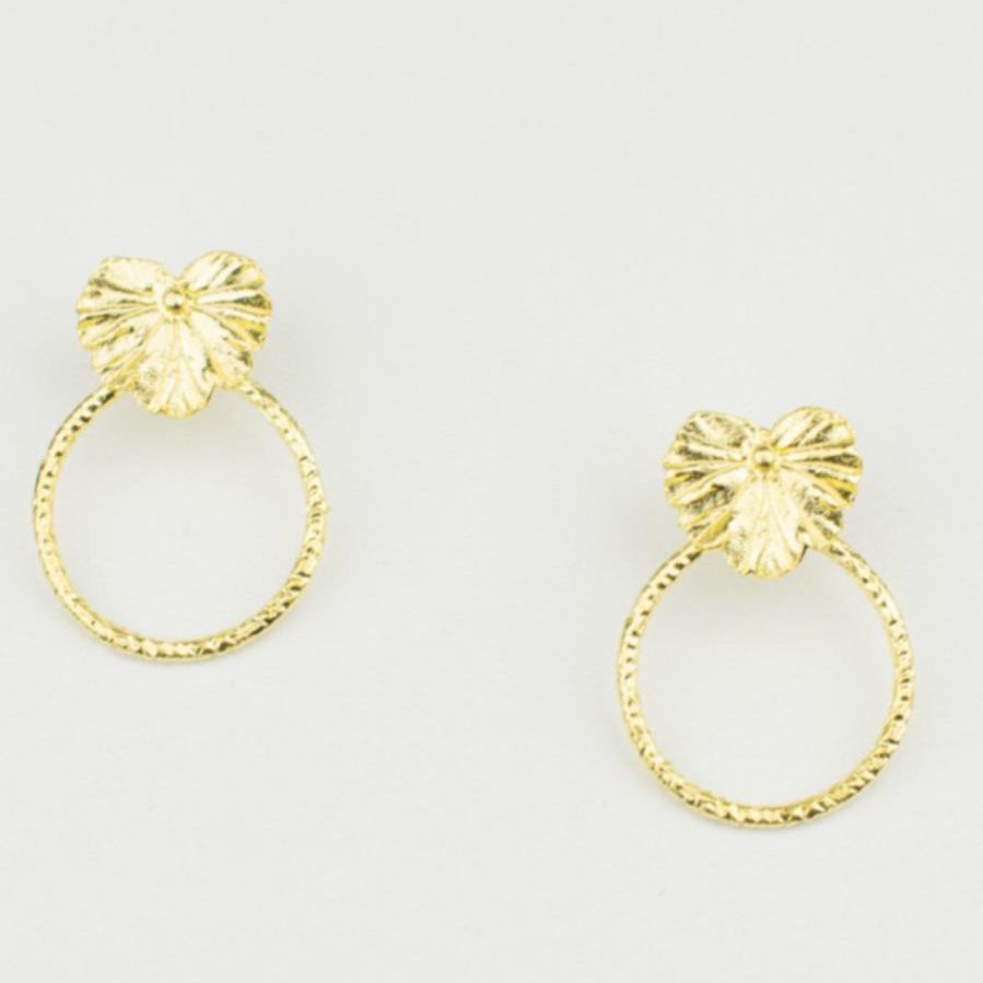 A pair of artisan-made 18K gold plated silver geranium leaf hoop earrings. The natural form of the leaf meets the classic design of a textured hoop, creating elegant botanical accessories.