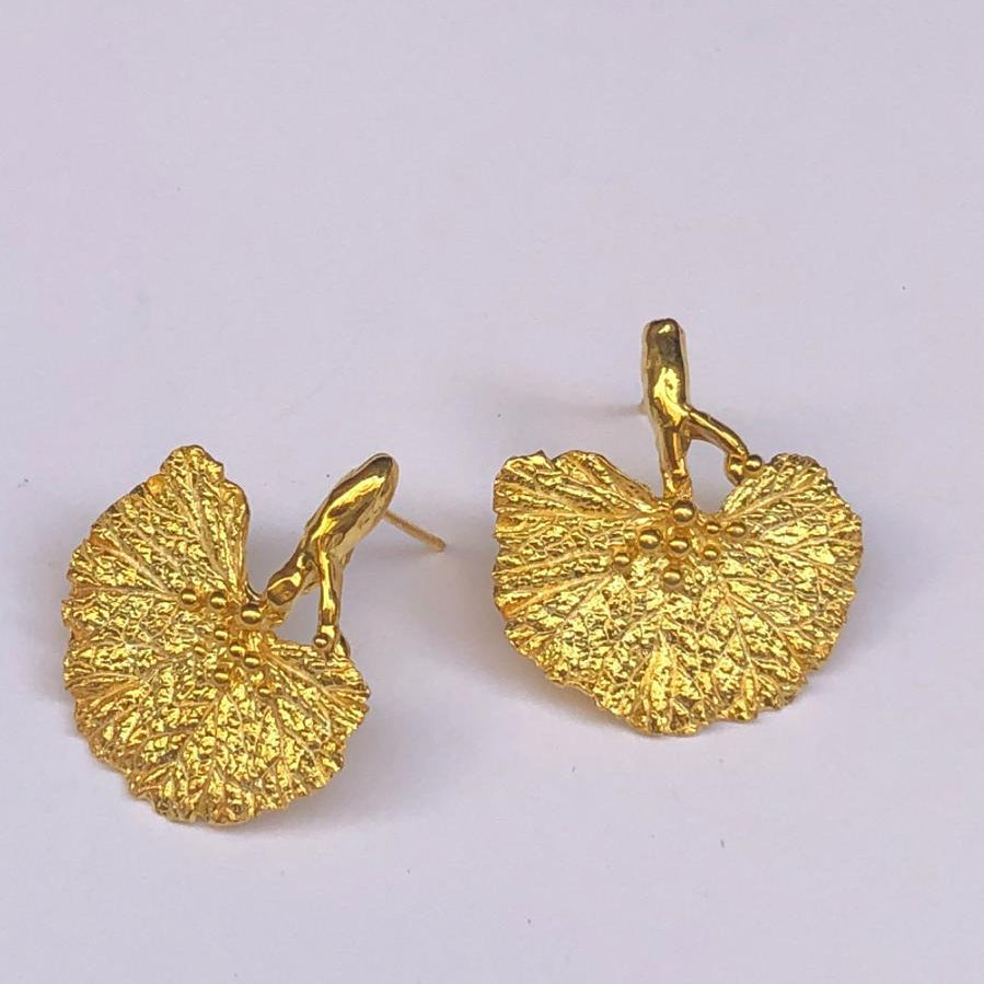 A pair of artisan-made 18K gold plated silver Ginkgo leaf earrings, capturing the symbolic fan shape from real nature casting. A delicate yet powerful botanical accessory for everyday elegance.