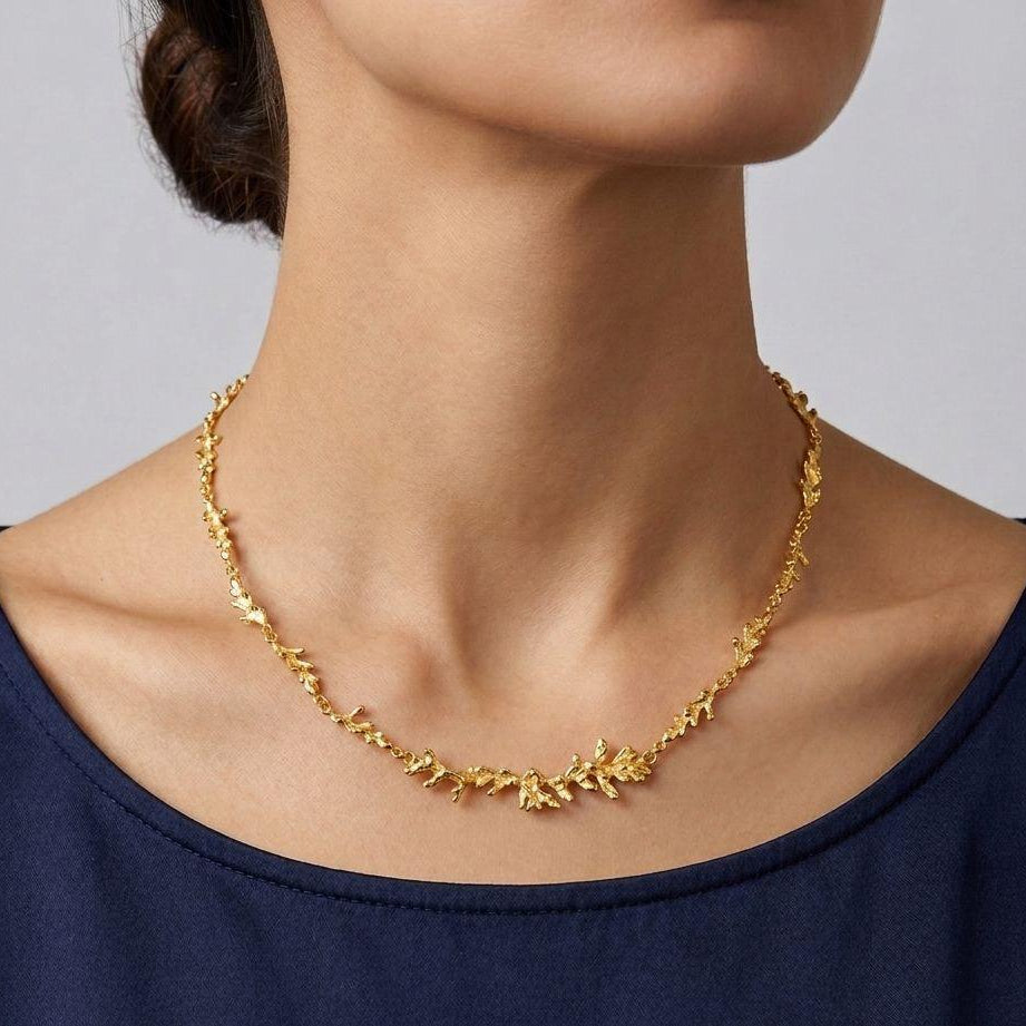 A handcrafted 18K gold-plated 925 sterling silver necklace featuring a continuous organic pine branch design, measuring 42 cm in length.