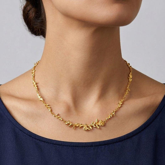 A handcrafted 18K gold-plated 925 sterling silver necklace featuring a continuous organic pine branch design, measuring 42 cm in length.