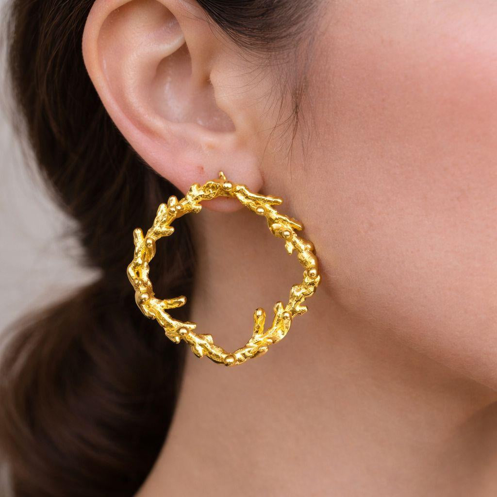 A pair of handcrafted 18K gold-plated 925 sterling silver stud earrings. Each earring forms a detailed, textured square frame inspired by organic pine branches, with the front view showing the intricate botanical pattern. The earrings are 3 cm by 3 cm.