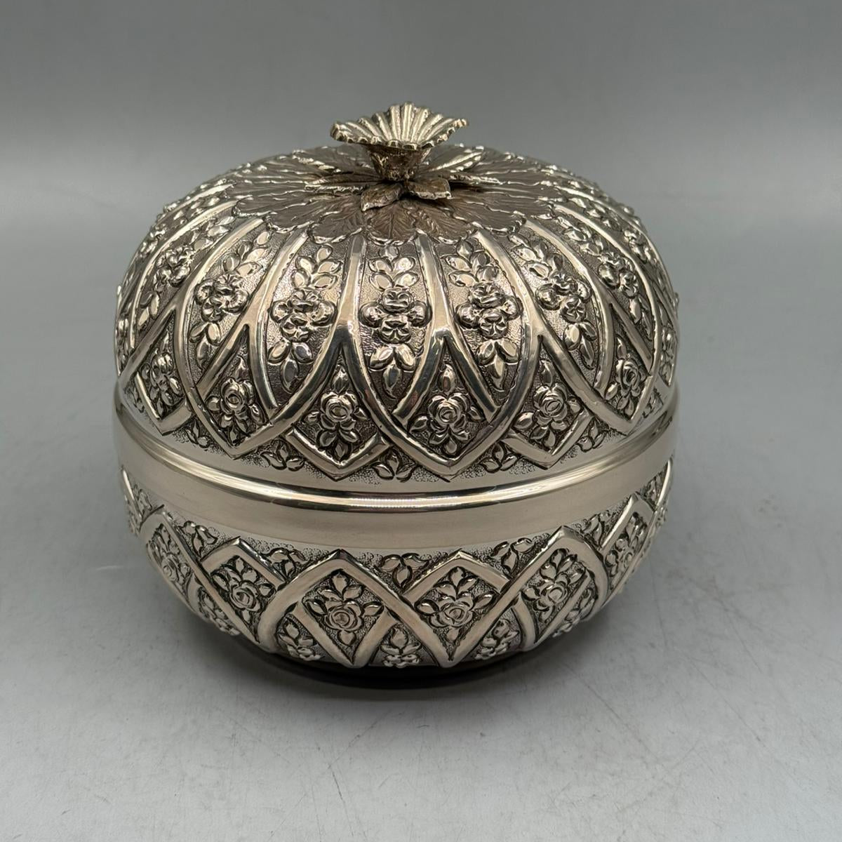 Front view of the handcrafted 900 silver bonbonniere featuring a ribbed body and domed lid with floral motifs.