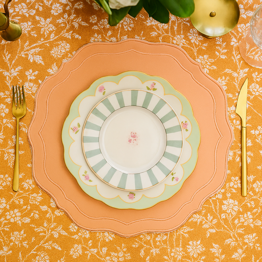 Orchid burnt orange square faux leather placemat styled with autumn-inspired tableware and gold flatware on a rustic wood dining table.