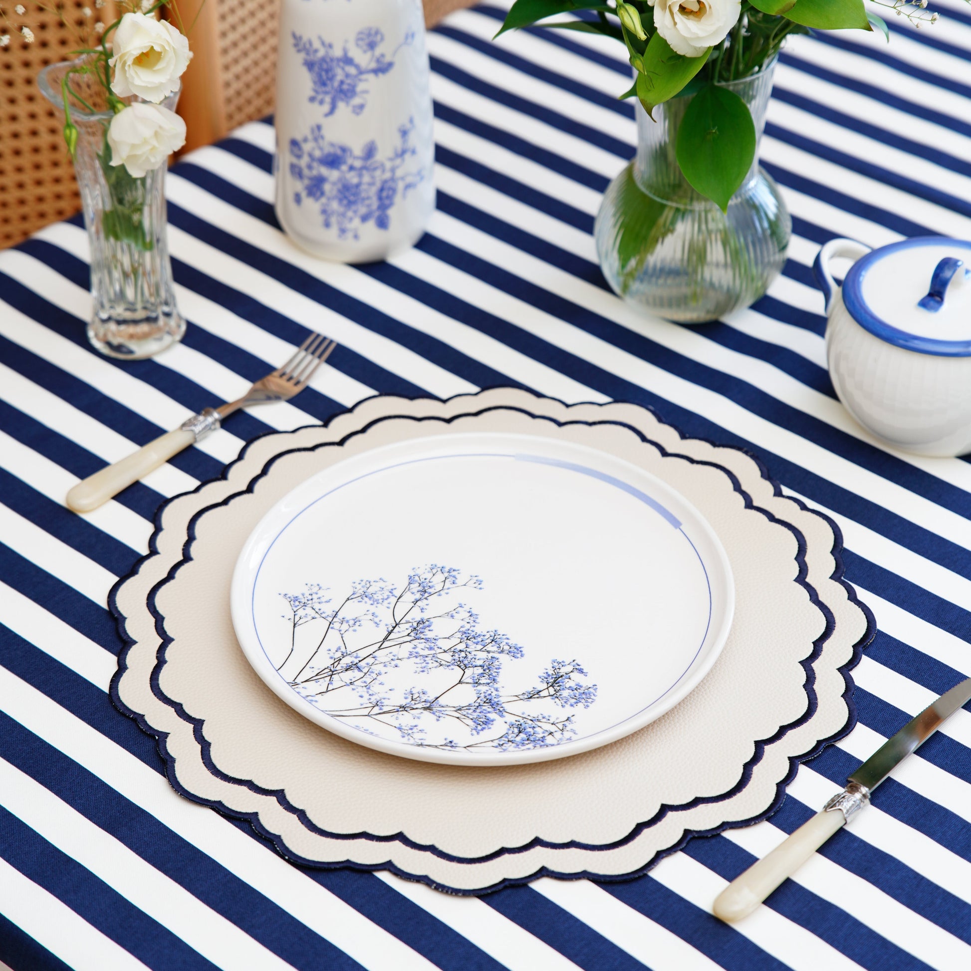 Scarlett White Round Vegan Leather Placemat – Expert craftsmanship combined with elegant navy embroidery, sustainable faux leather, and superior stain-resistant finish. Ideal for upscale dining. Exclusively at PNR Decor.