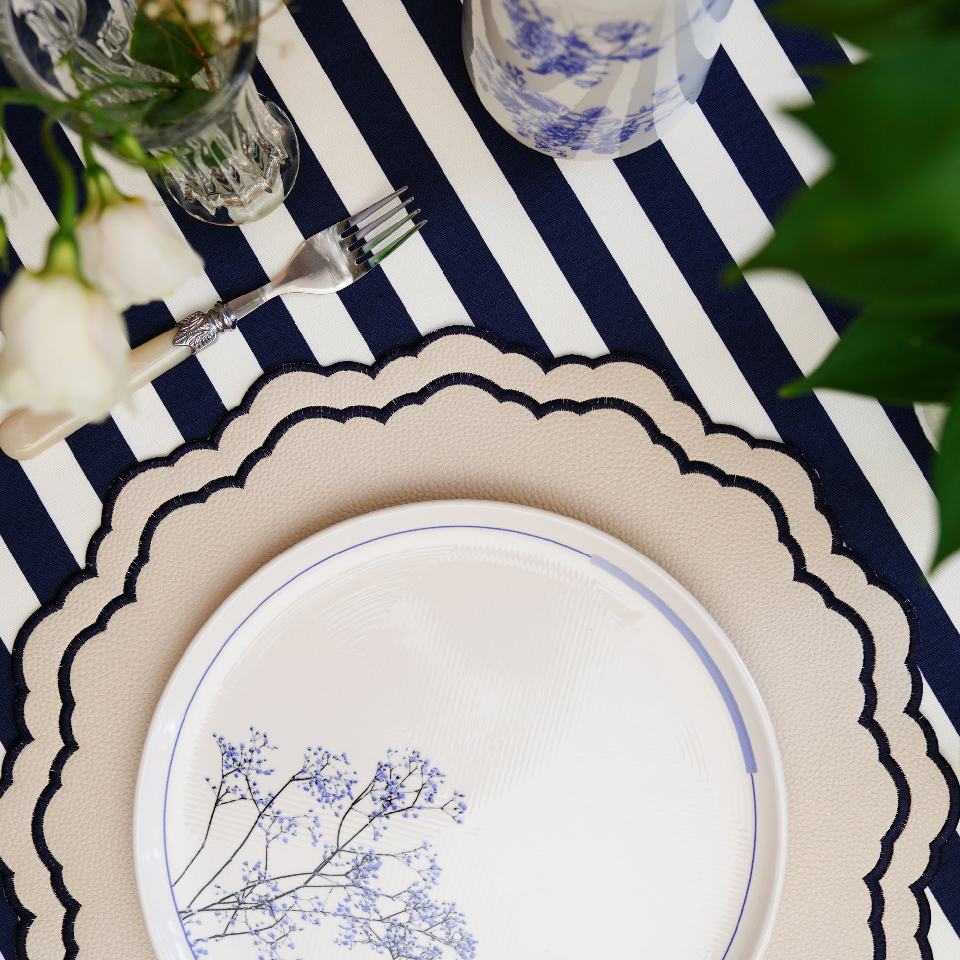Scarlett White Navy Premium Round Faux Leather Placemat – Handmade using eco-conscious materials, adorned with sophisticated embroidery, offering remarkable stain resistance and durability. Exclusively by PNR Decor.