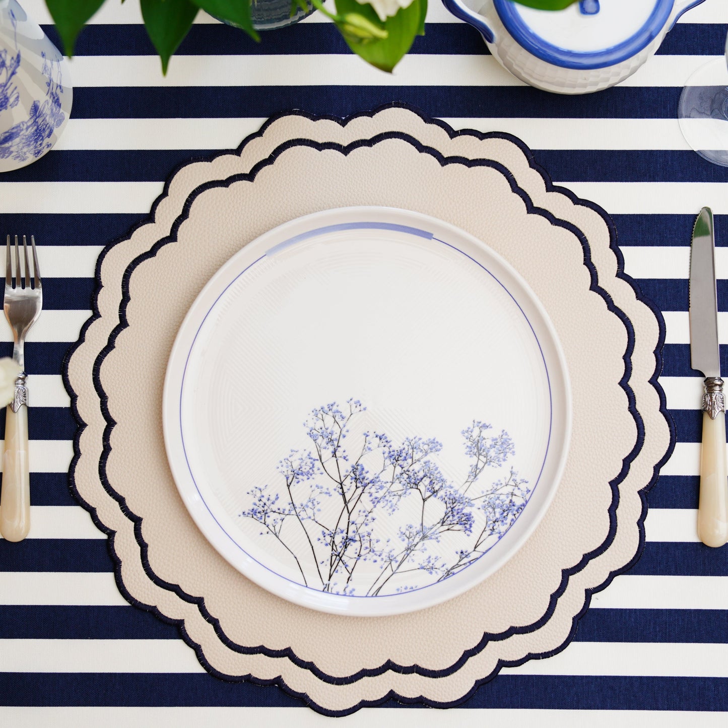Scarlett White Navy Faux Leather Placemat – The epitome of elegance and functionality, handcrafted with cruelty-free materials, featuring refined navy embroidery and a double-layered stain-resistant finish. A PNR Decor exclusive.