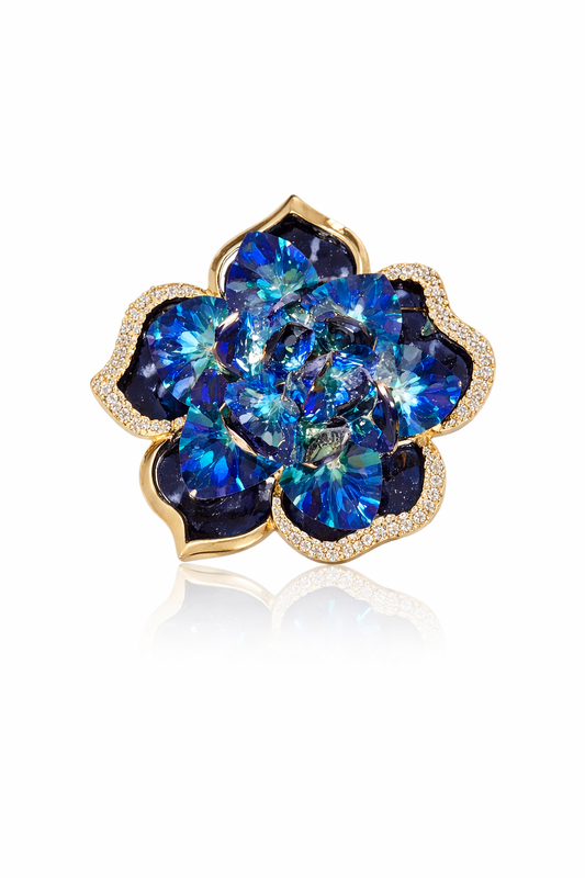 A sophisticated vintage-style gold-plated brooch featuring deep navy and vibrant red enamel accents, decorated with sparkling clear crystals in an elegant royal emblem design.