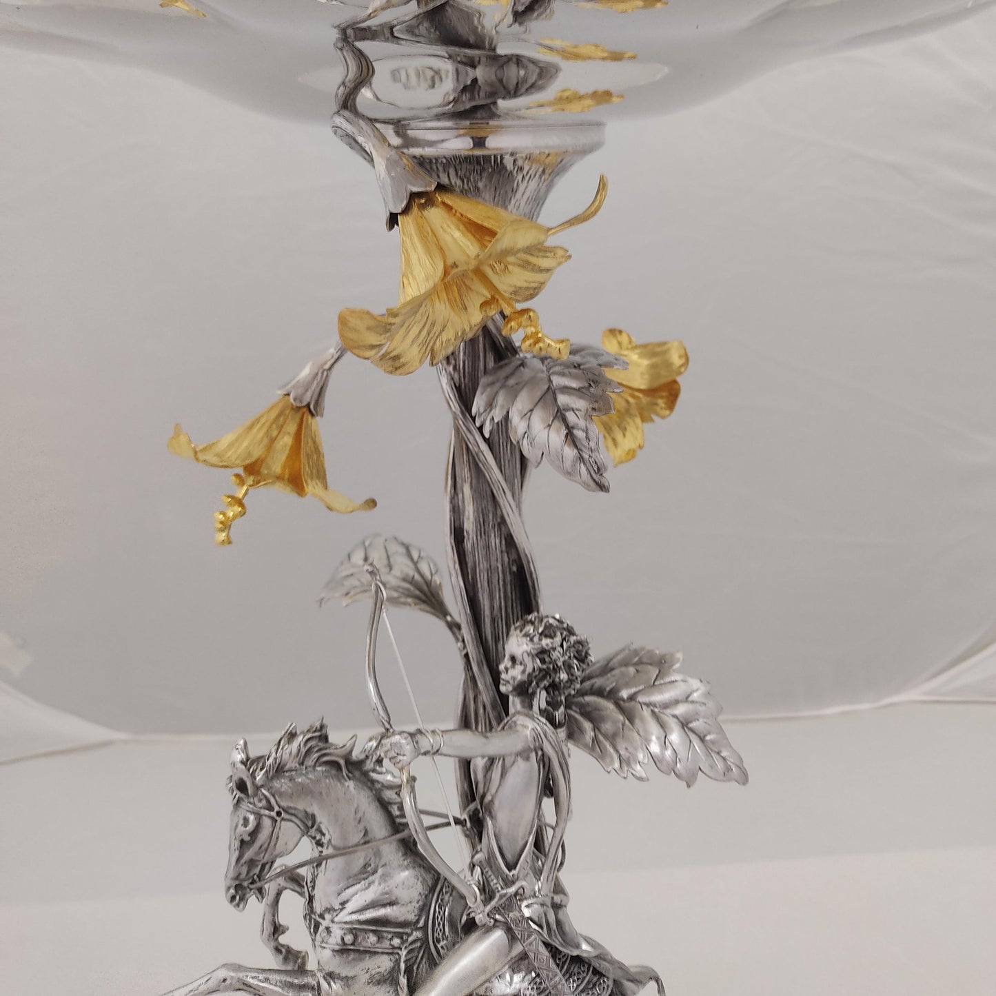 Close-up of silver and gilded floral details on antique centerpiece