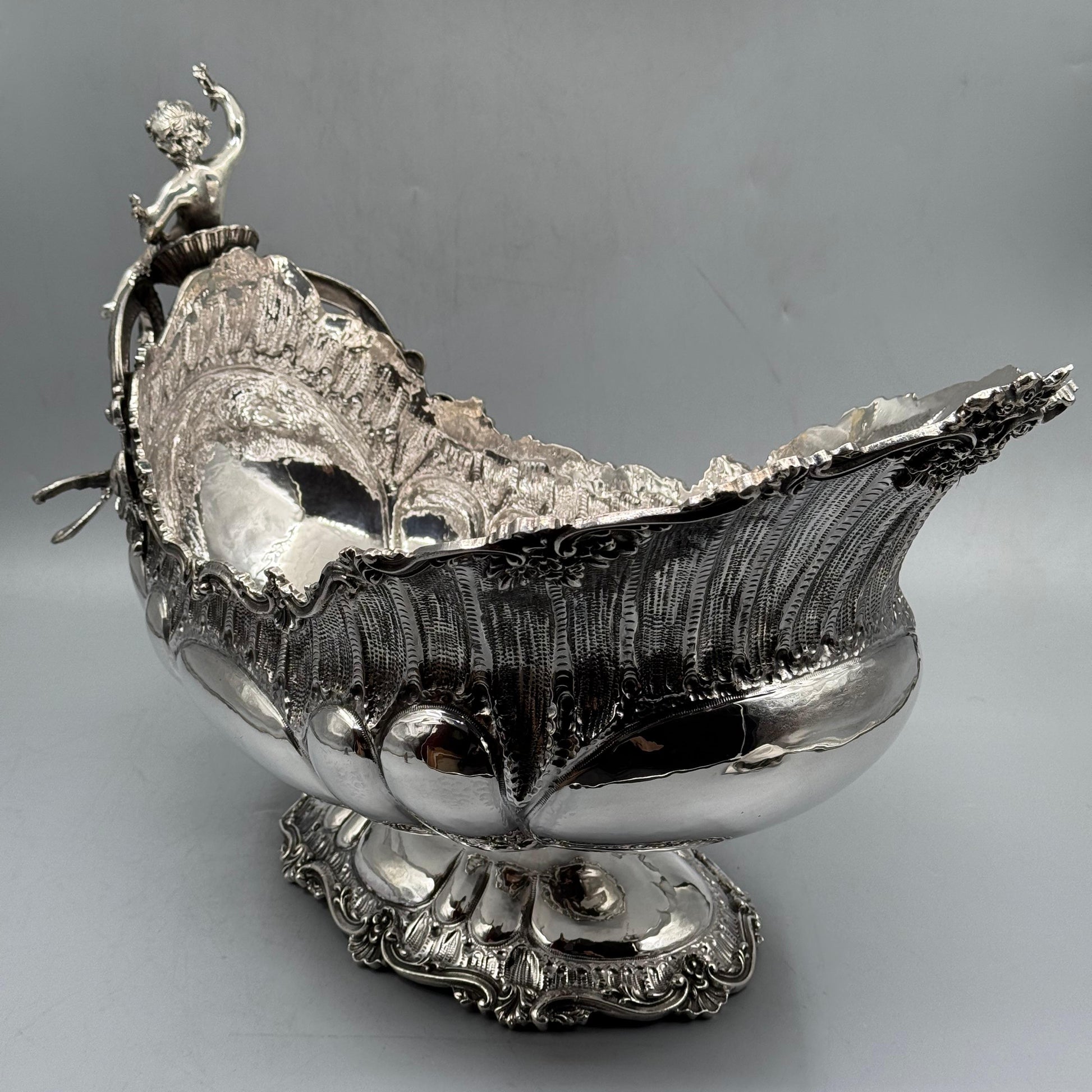 Angled view of antique silver gondola centerpiece with ornate Rococo details