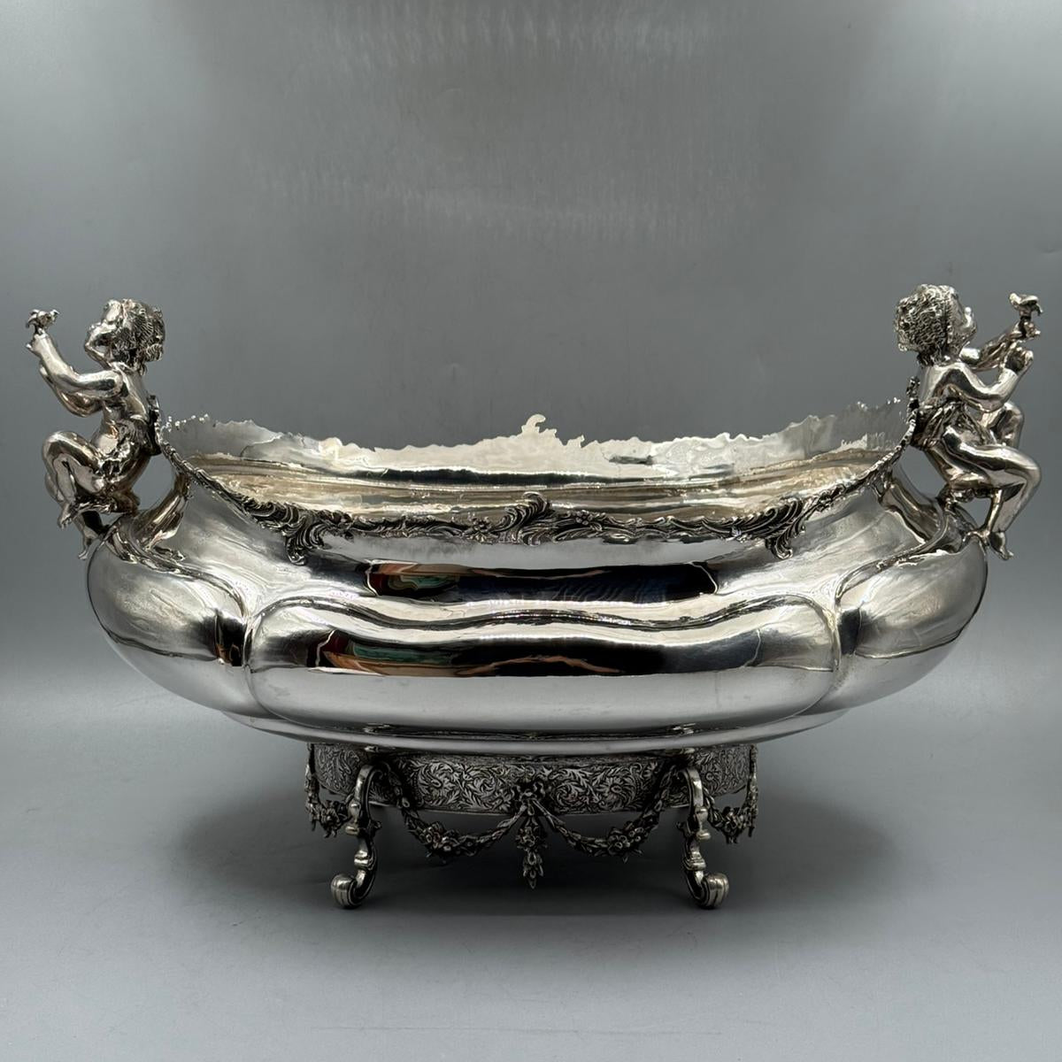 Front view of antique silver gondola bowl with two putti figures