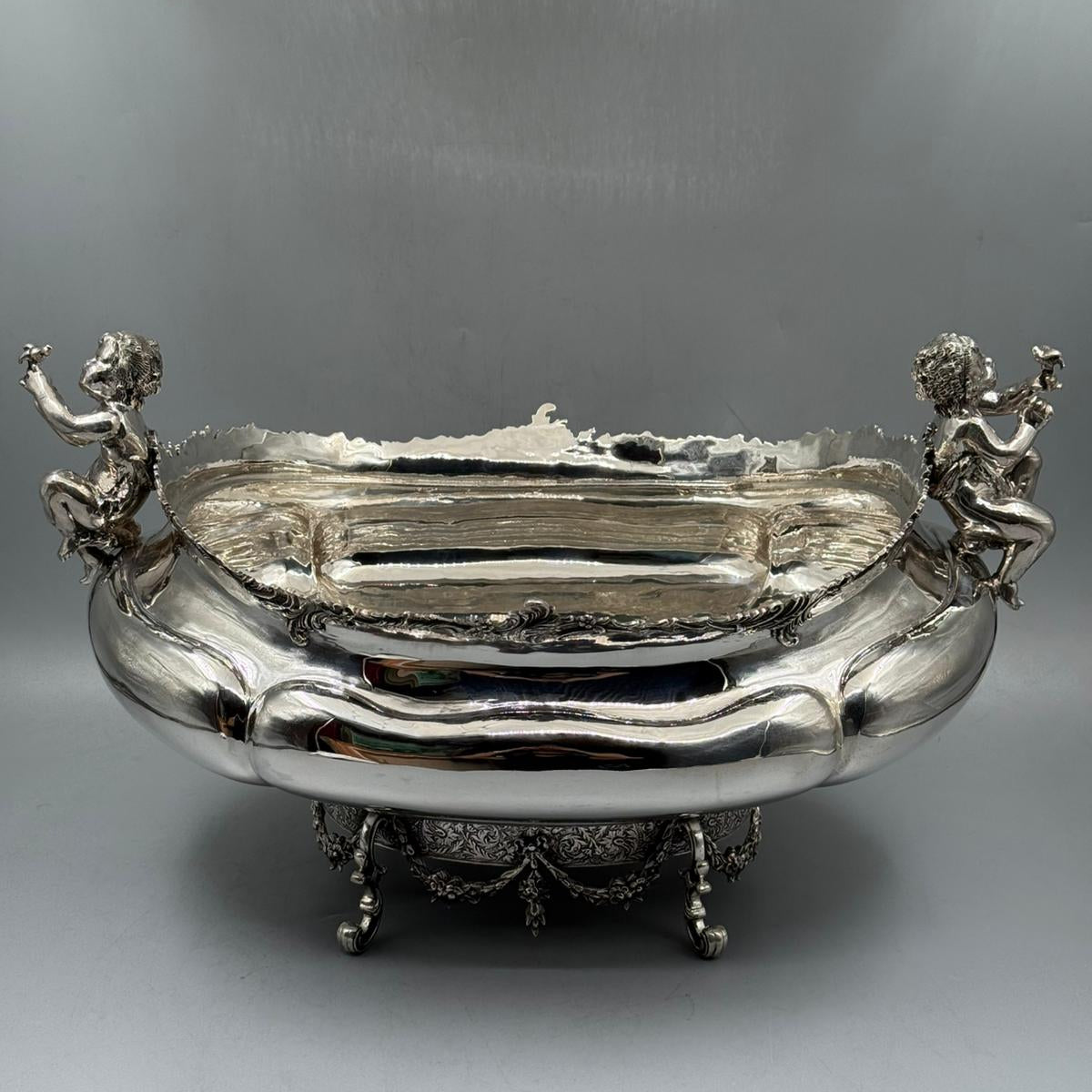 Full view of ornate antique silver gondola centerpiece with cherub details