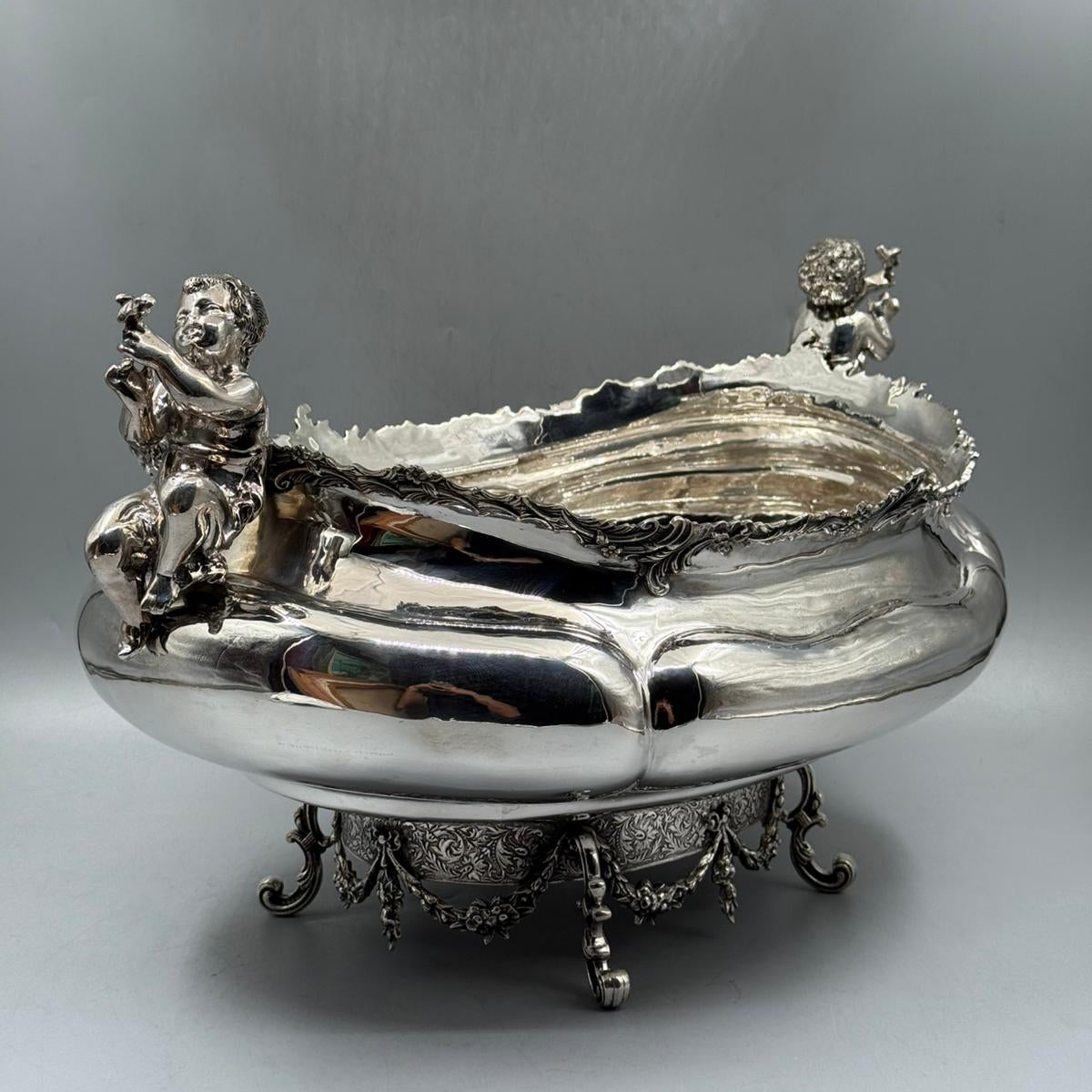 Side view of antique silver gondola bowl with cherub figures