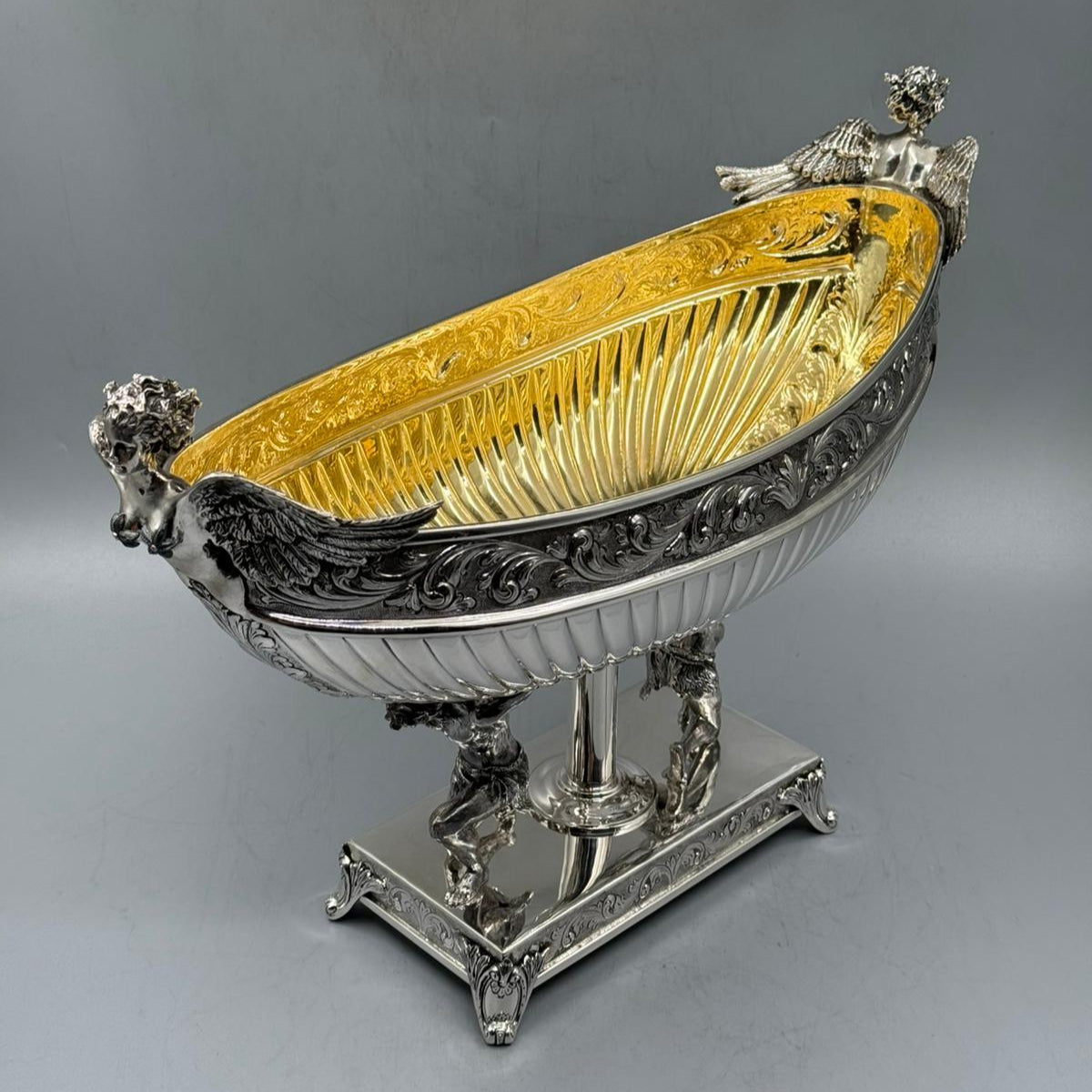 Ornate antique silver gondola with Hercules figures and gilded interior, angled view