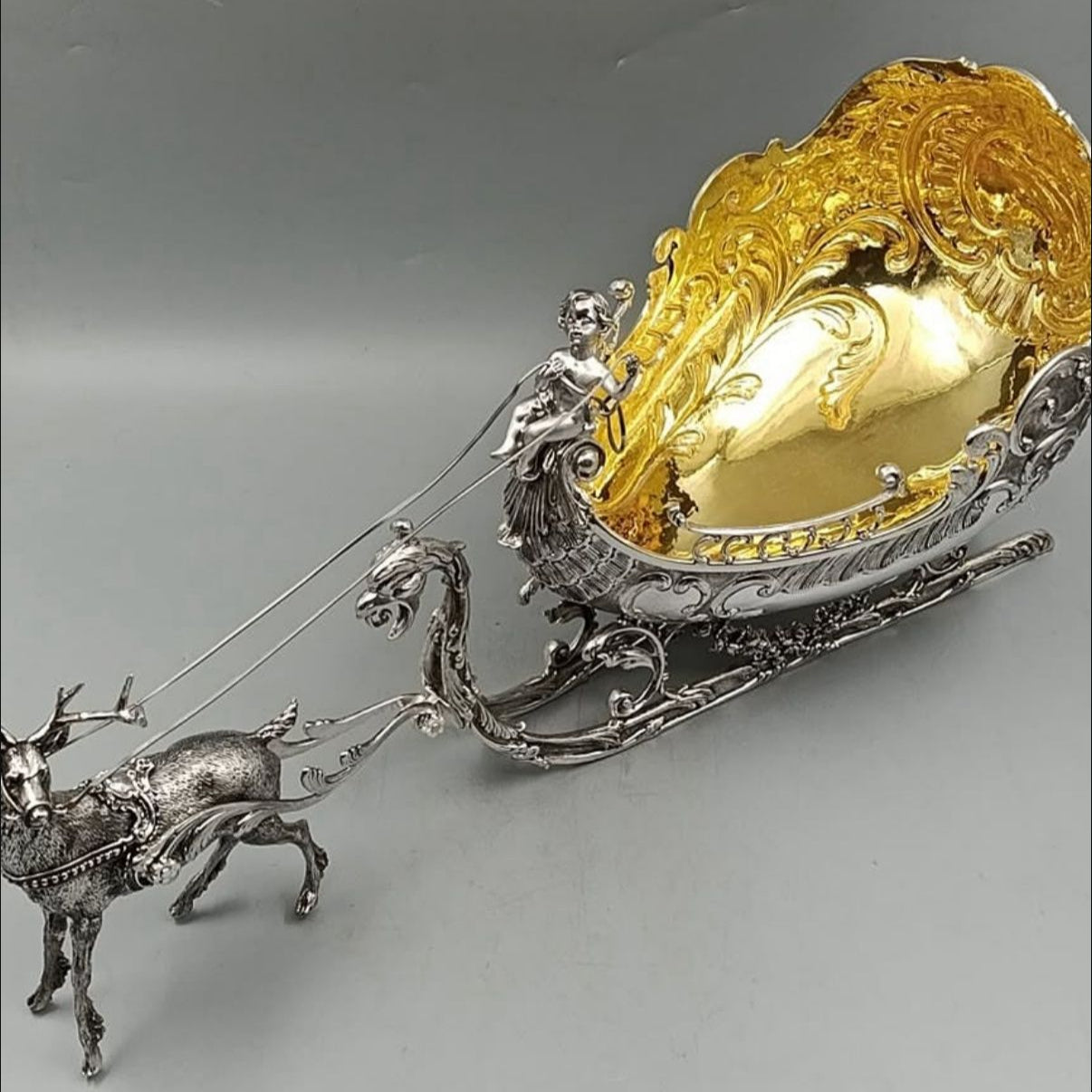 Top angled view of antique silver reindeer sleigh with gilded interior