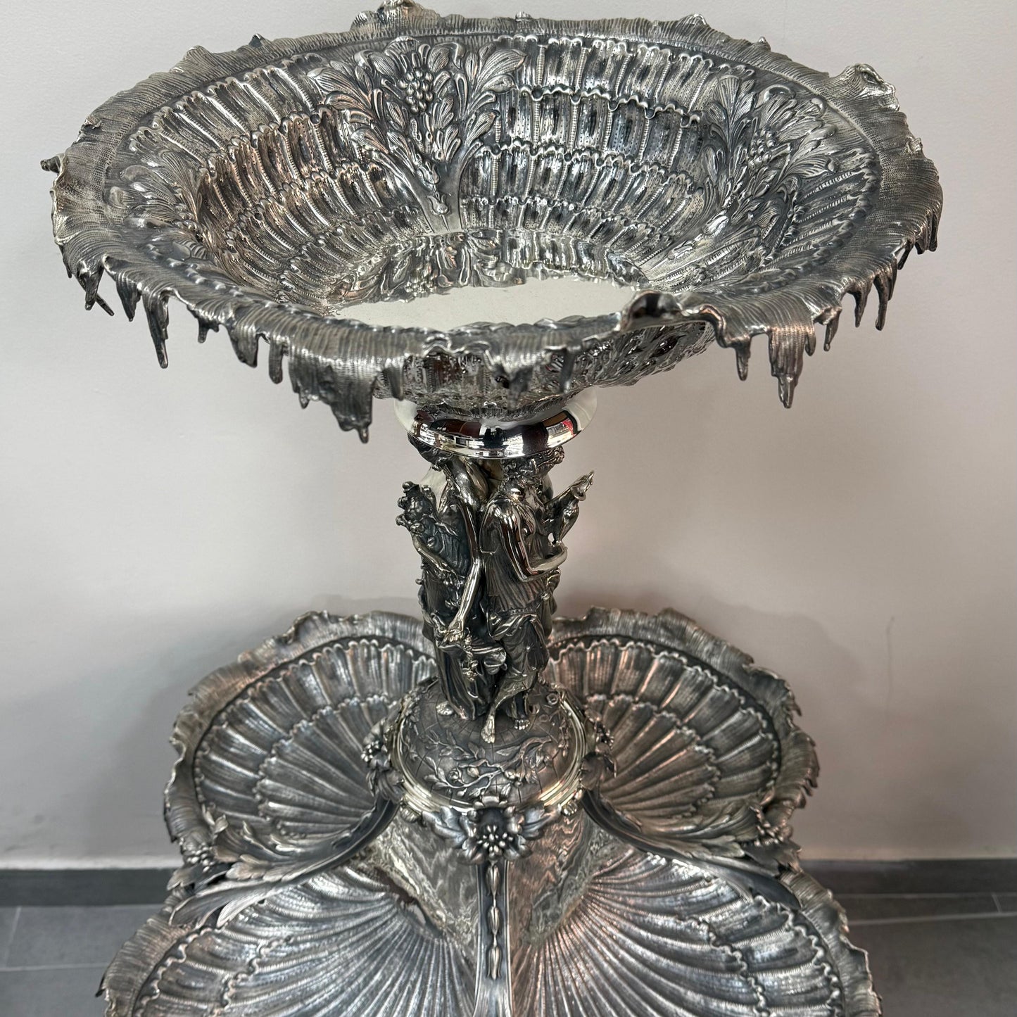 Angled view of ornate antique silver centerpiece with shell design and figures