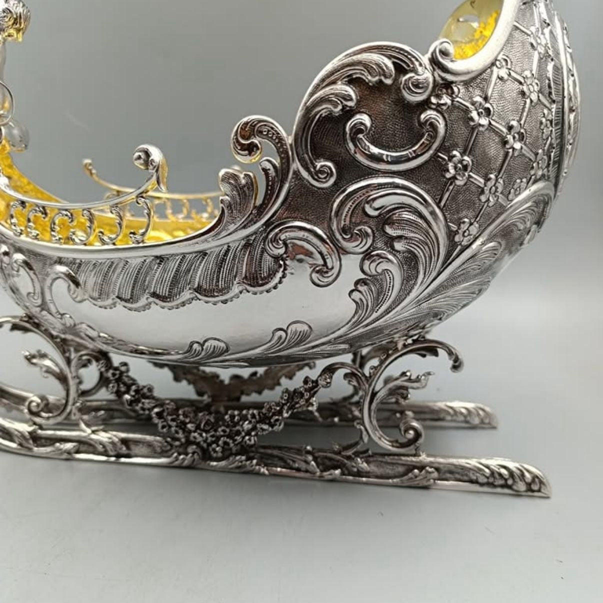Detailed view of Rococo engravings on antique silver sleigh centerpiece