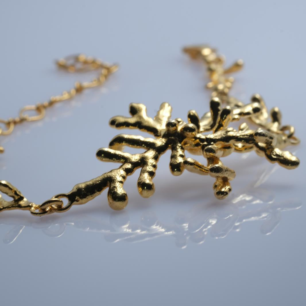 Close-up on the intricate overlapping pine needles of the bracelet's centerpiece, capturing the true essence and texture of a forest branch.