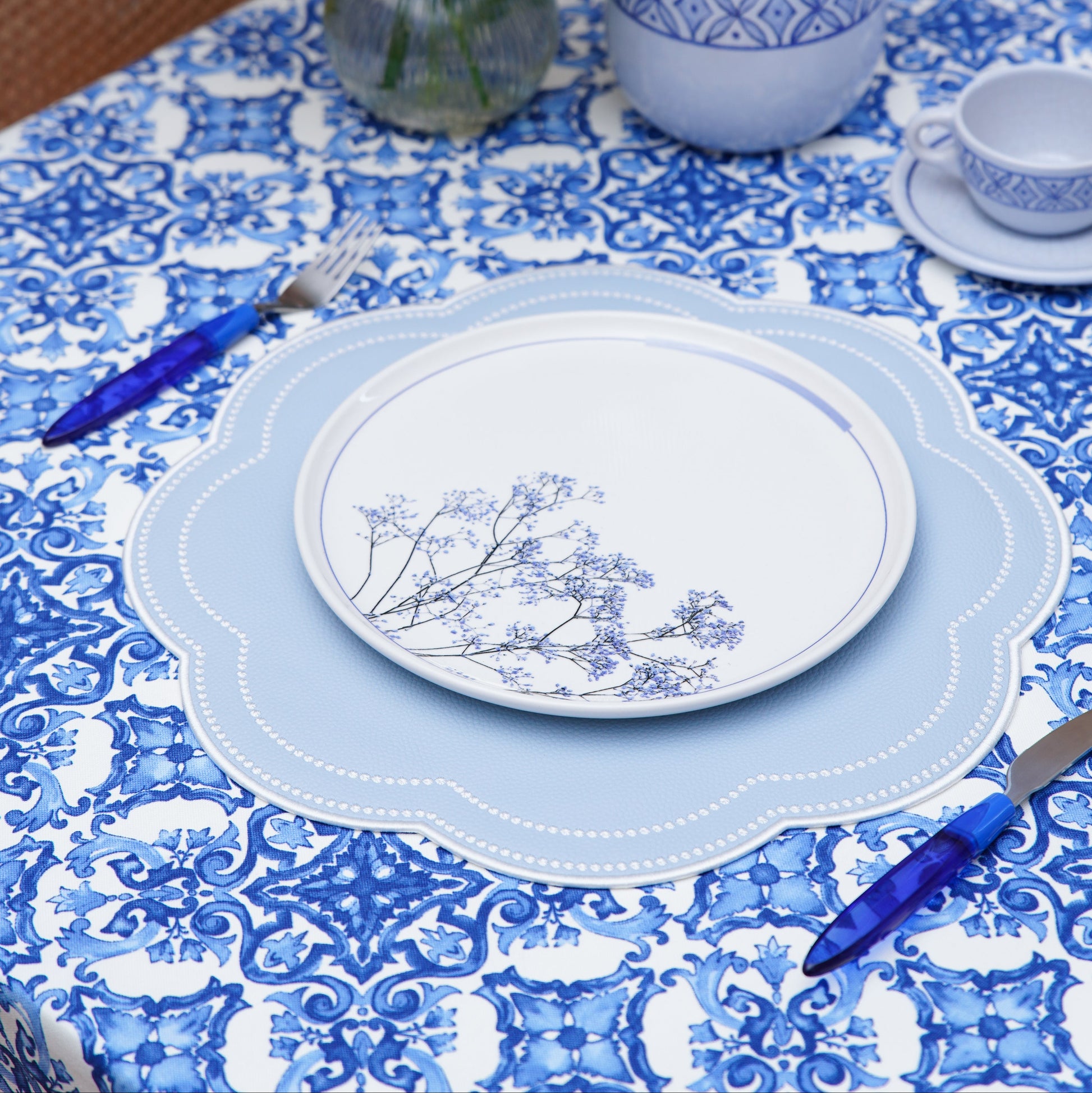 Close-up of the blue and white damask pattern on the tablecloth, showing detailed ornamental motifs and woven texture
