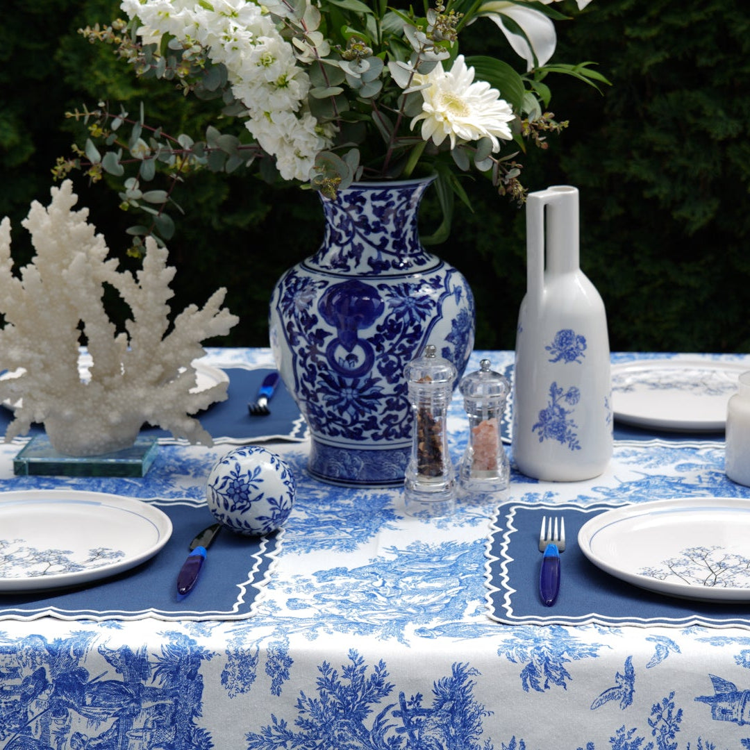 Close-up detail of the blue and white scenic toile print tablecloth showing intricate countryside illustrations and fabric texture