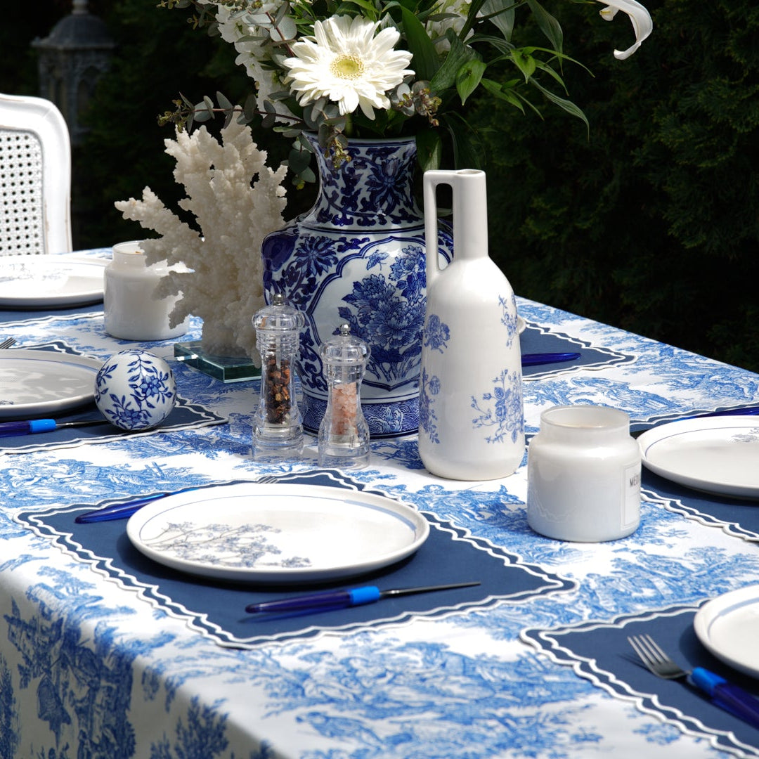 Blue and white toile tablecloth styled for an outdoor dining tablescape with matching blue-and-white ceramics and plates
