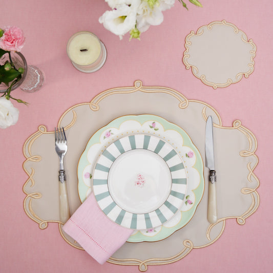 Oval faux leather placemat paired with matching coaster in a refined table setup