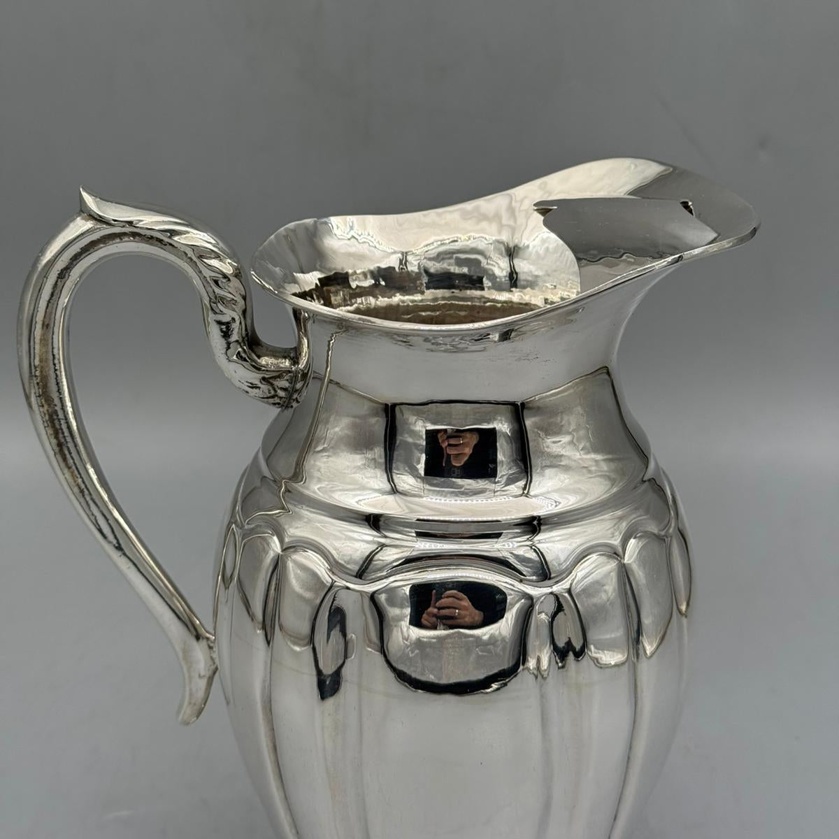 Side view of elegant silver water jug with curved handle by PNR Decor ship from USA