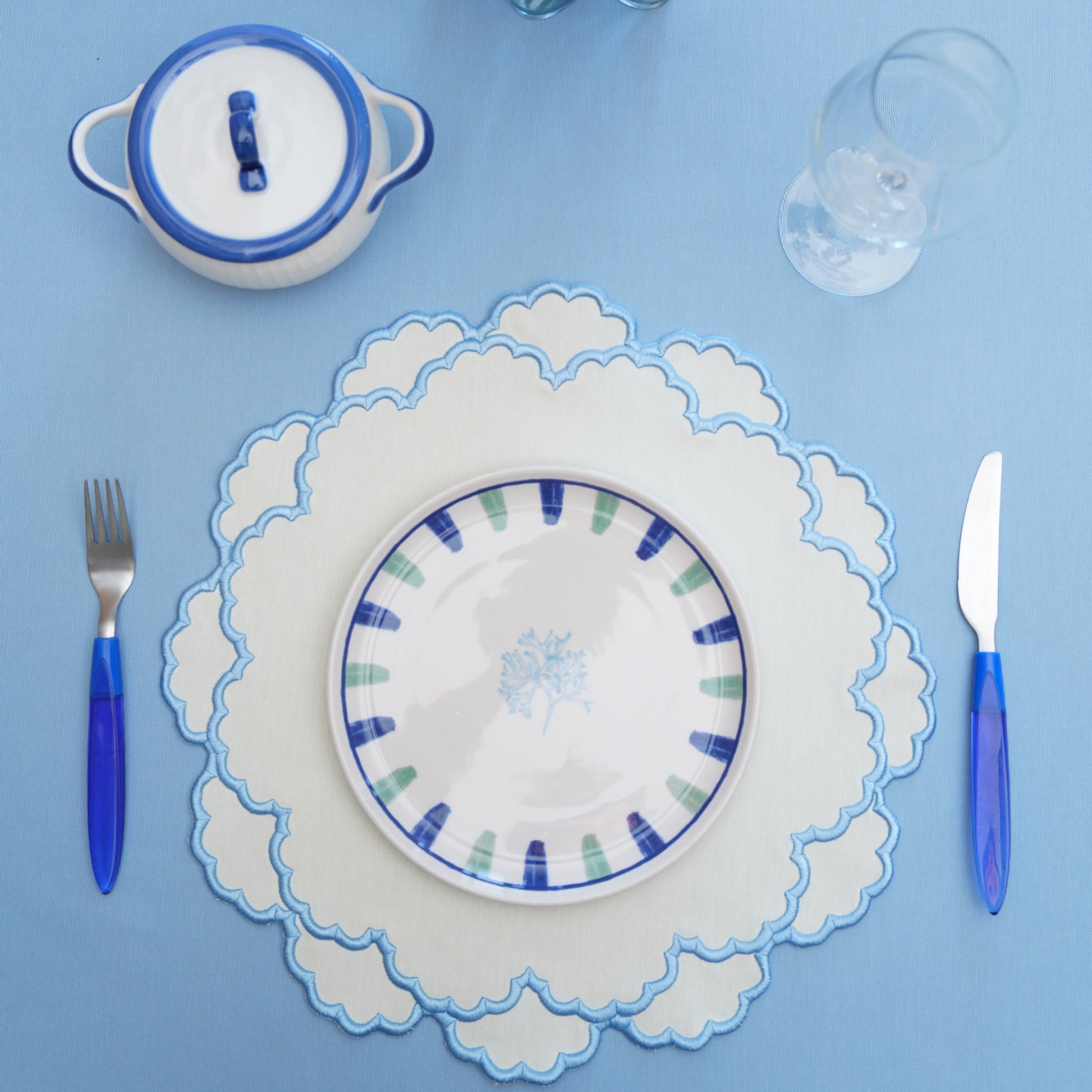 Fabric placemat with scalloped edging styled for formal table settings