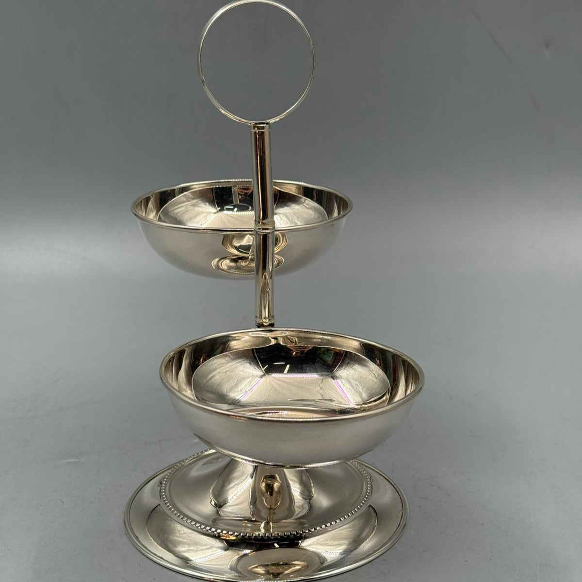 Decorative double serving dish in silver metal with round handle for easy serving