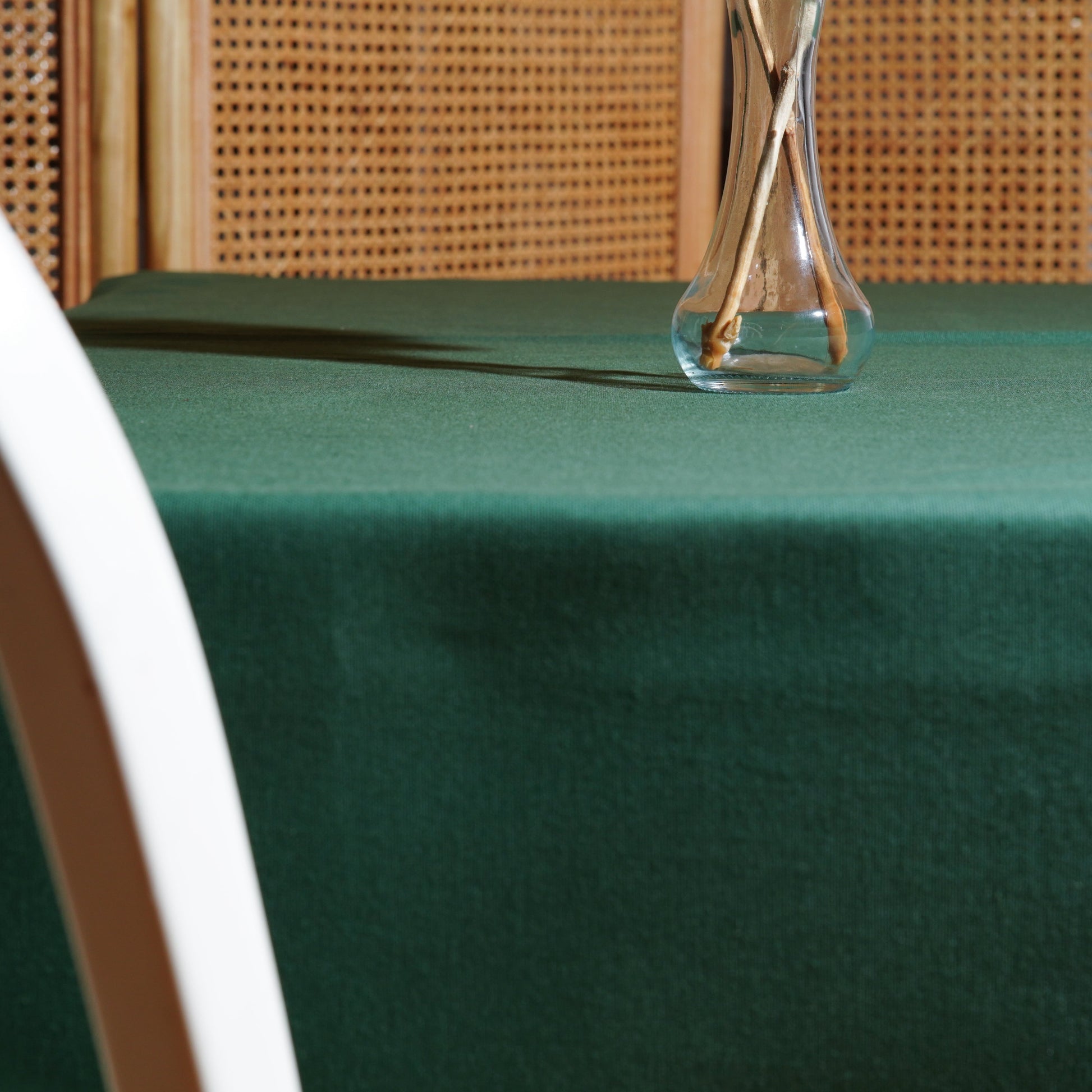 Deep green table linen draped over the table edge, highlighting the clean hem and elegant fall