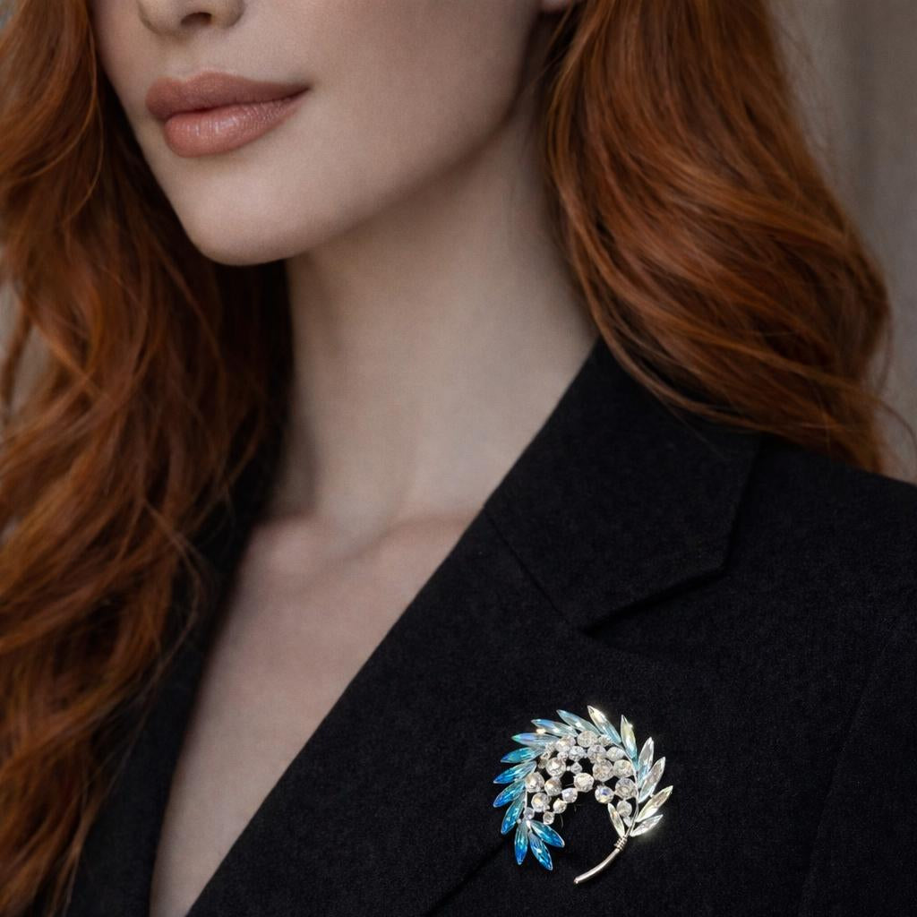 A sophisticated gold-plated branch brooch adorned with clear marquise-cut crystals as leaves, featuring two delicate teardrop pearls hanging from the stems.