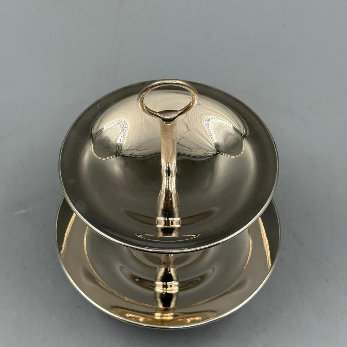 Elegant silver two tier serving plate with central ring handle, stylish table centerpiece