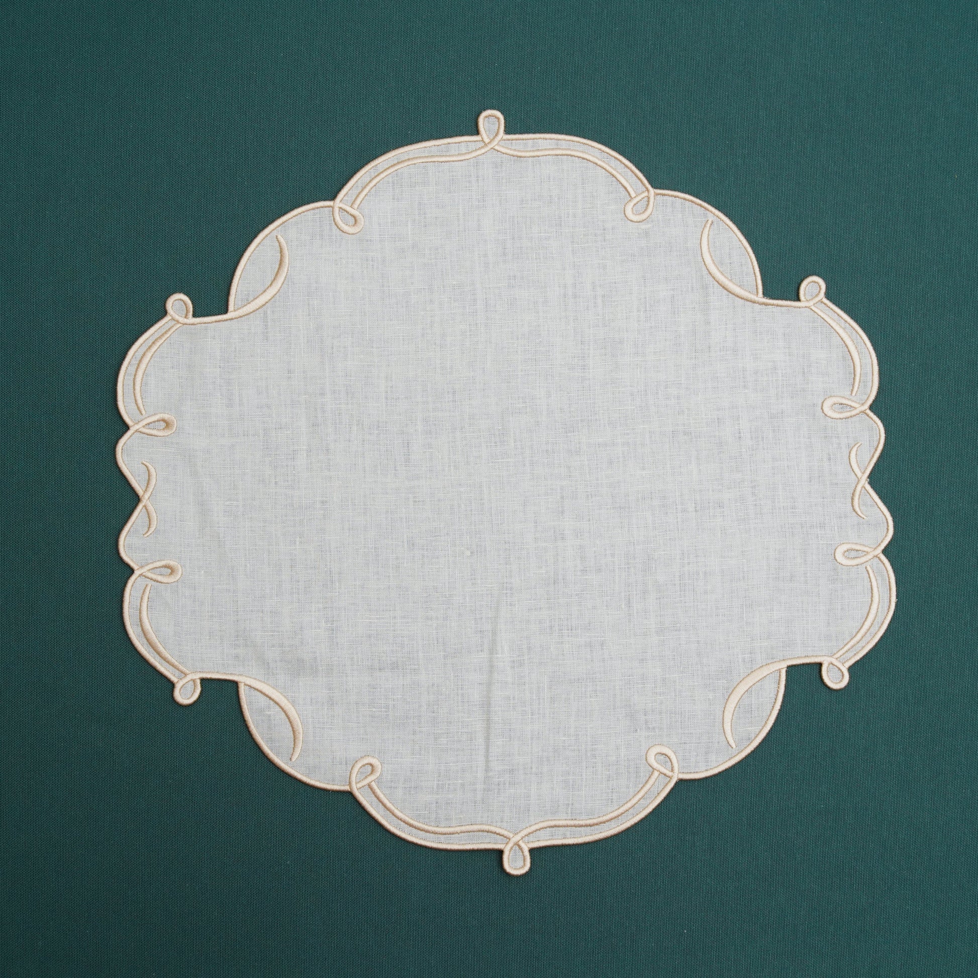 Ivory placemat with golden edges placed on a decorative dining table