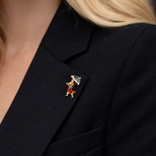Close up of vintage style enamel brooch featuring a woman in a red dress walking with a black umbrella by PNR Decor ship from USA