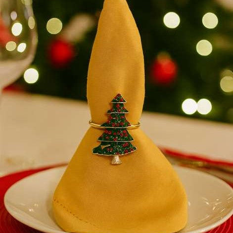 Front view of festive green enamel Christmas tree napkin ring with gold accents.