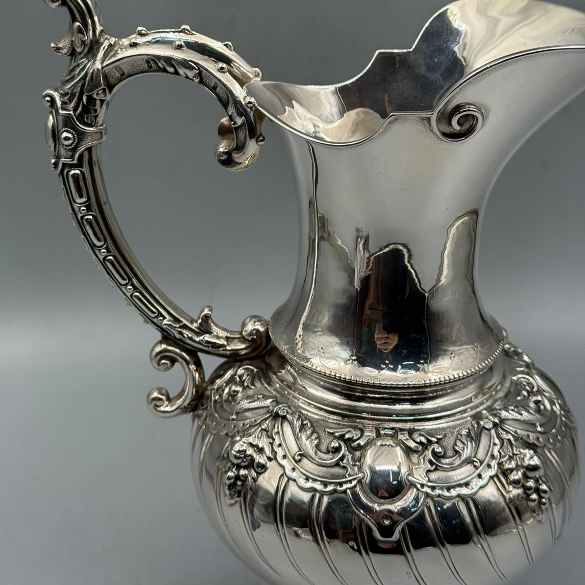 Detailed view of floral garland relief on the shoulder of silver jug by PNR Decor ship from USA