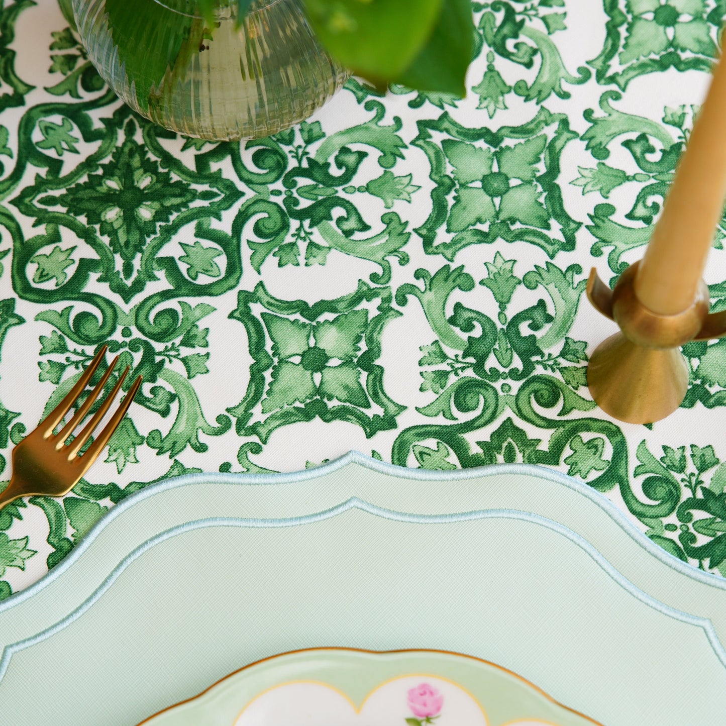 Close-up of the green ornamental damask pattern tablecloth showing detailed motifs and woven texture