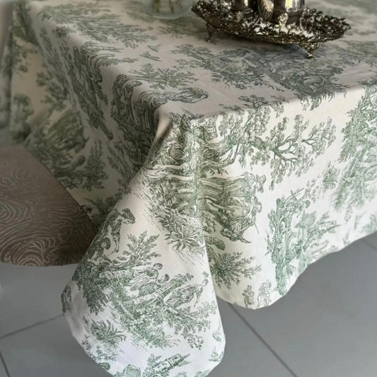 Green toile rectangular tablecloth on a dining table with a vintage tea set tray, featuring scenic pastoral illustrations