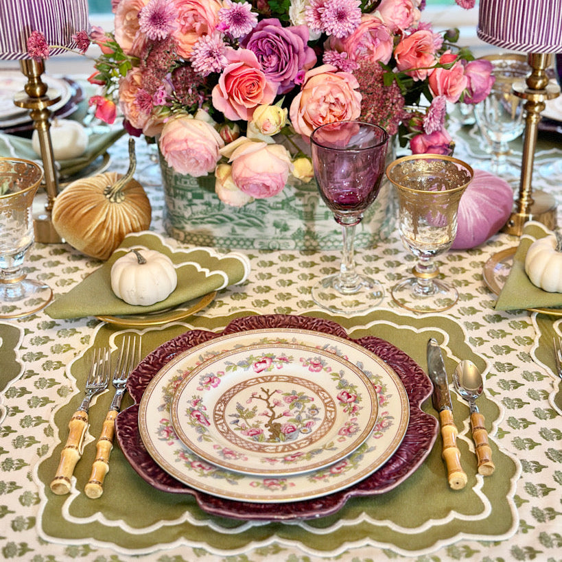 Elegant green and white placemat with delicate embroidery, ideal for refined dining table styling.
