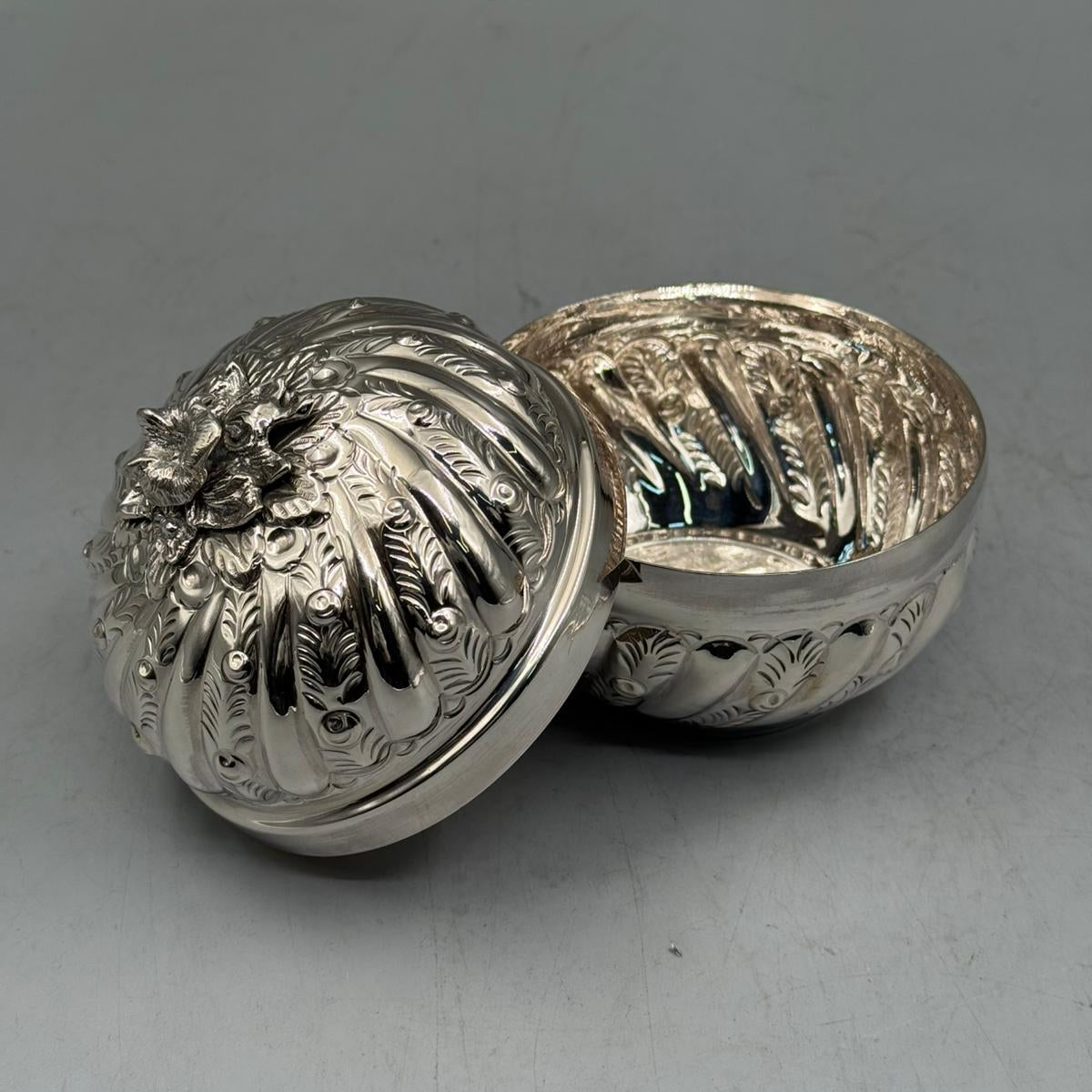 Close-up of the meticulous hand-engraved leaf patterns and row-inlaid textures on the 900 sterling silver bonbonniere.