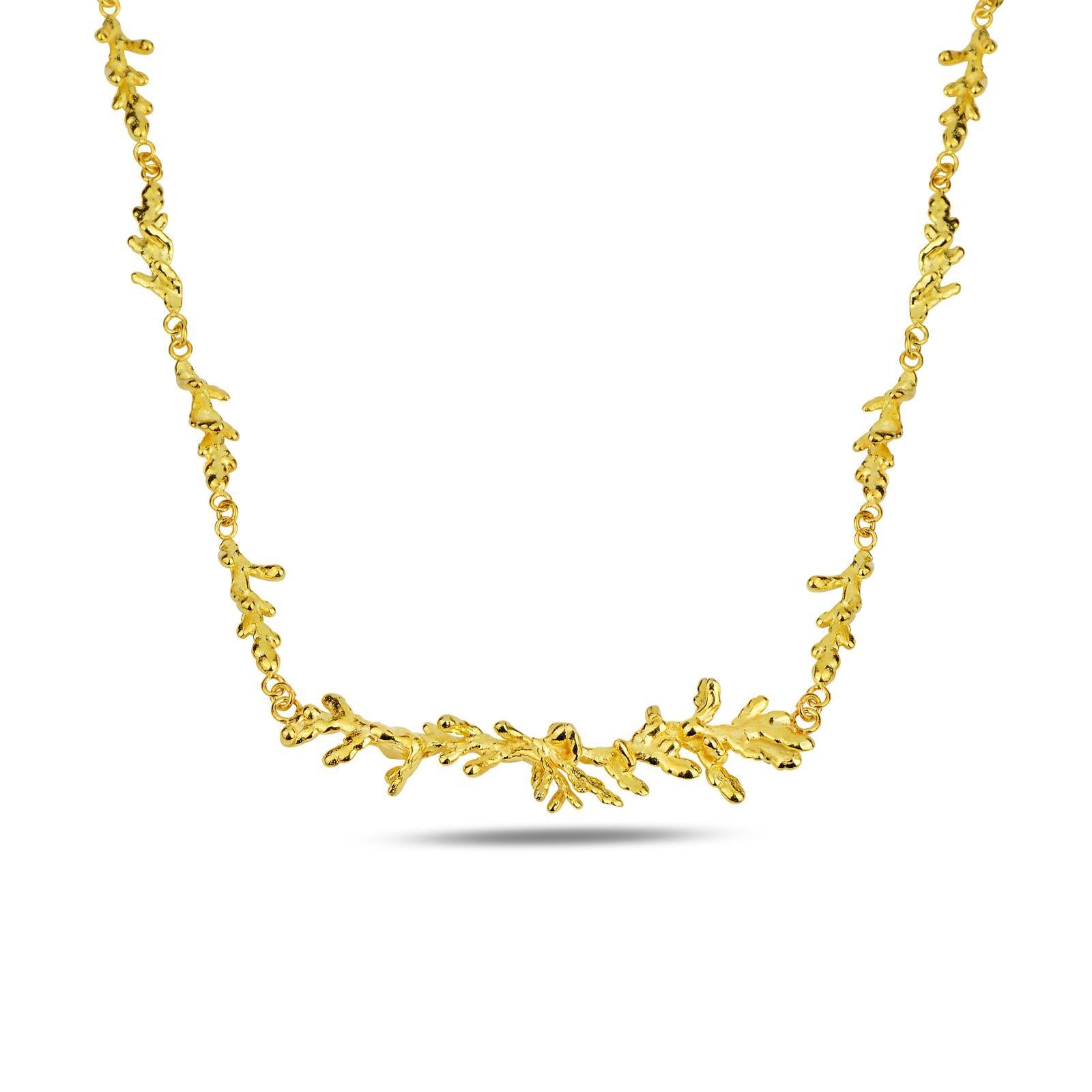 Close-up view of the detailed organic texture of the gold-plated silver pine branch necklace. The intricate knots and grain of real nature casting are clearly visible.