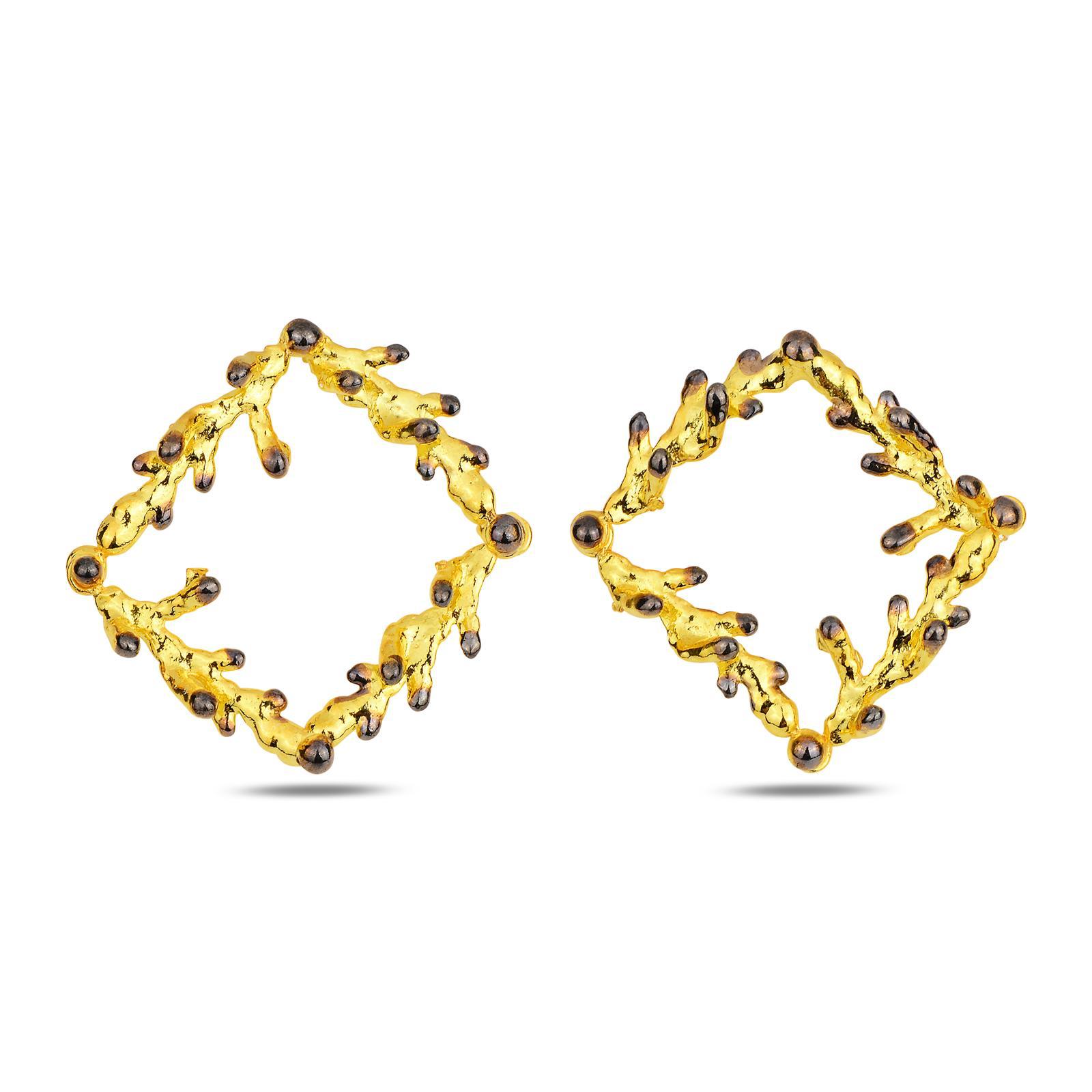 Front and side profile of the artisan-made geometric botanical earrings. The square frame made of textured gold and black pine twigs offers a modern yet rustic nature-inspired aesthetic.