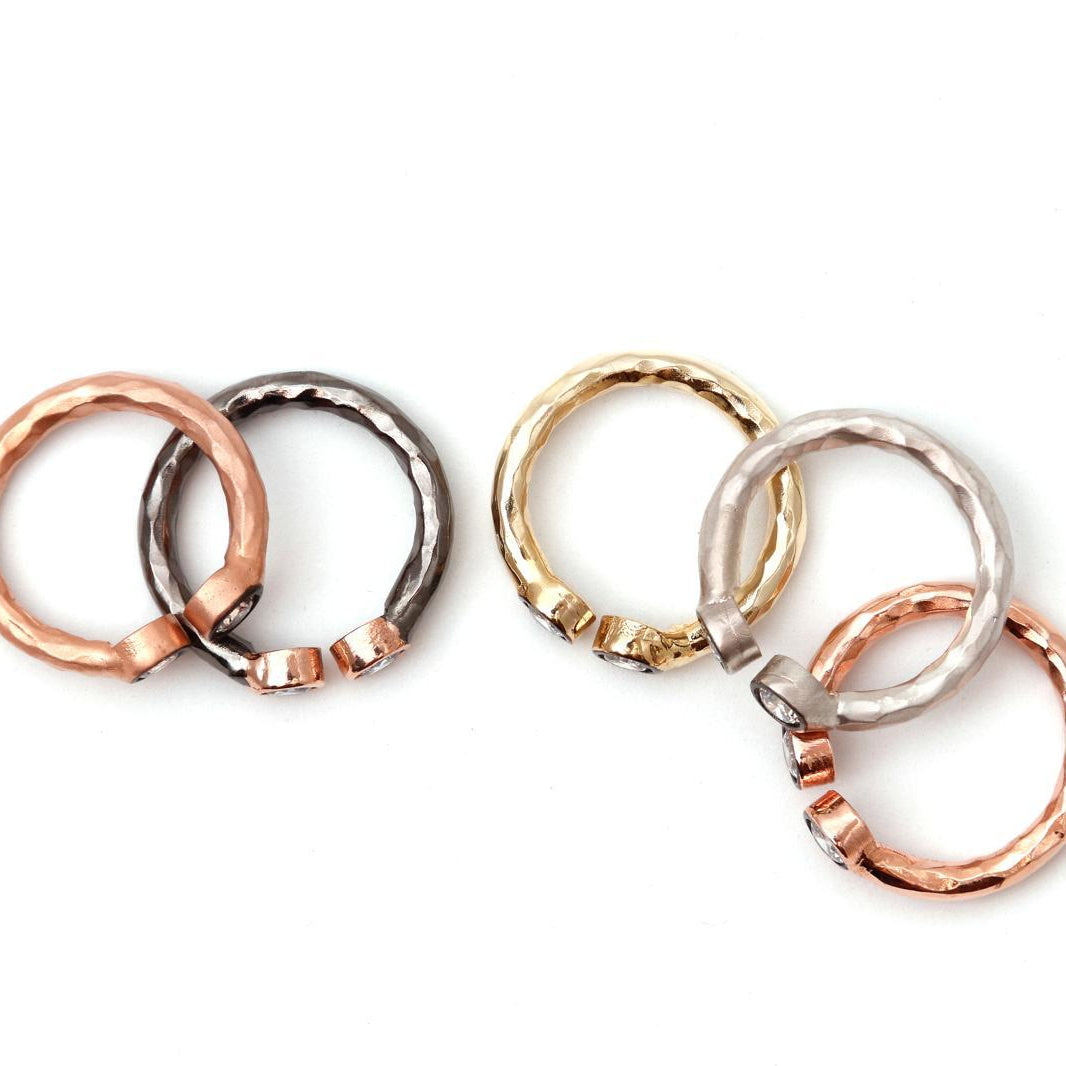 Close-up view of the dainty hammered open rings, highlighting the intricate rustic surface and the beautiful brilliance of the clear zircon stones.