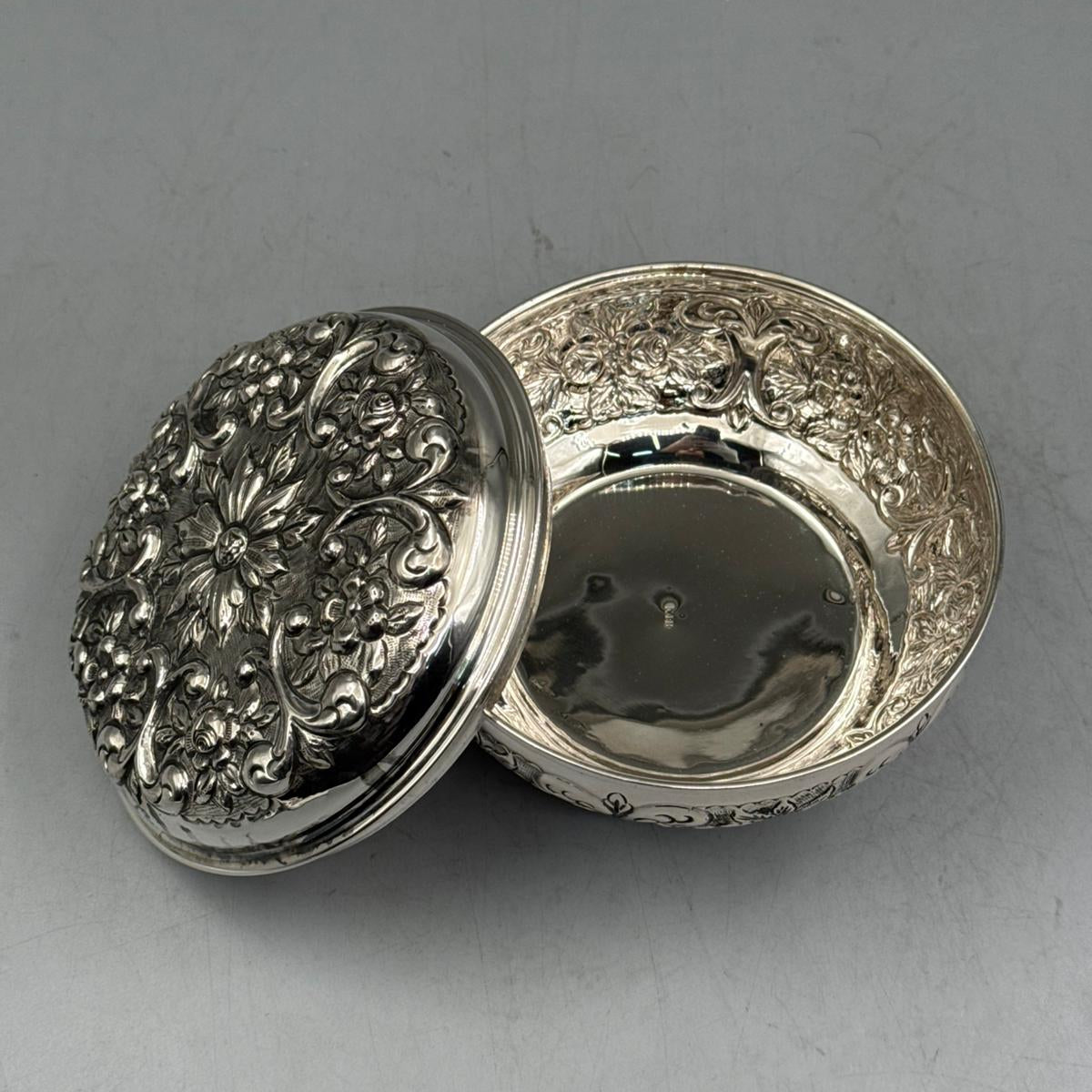Side view of the 270g solid silver triple-footed bonbonniere with the lid aside, showcasing the ornate feet and high-polish interior.