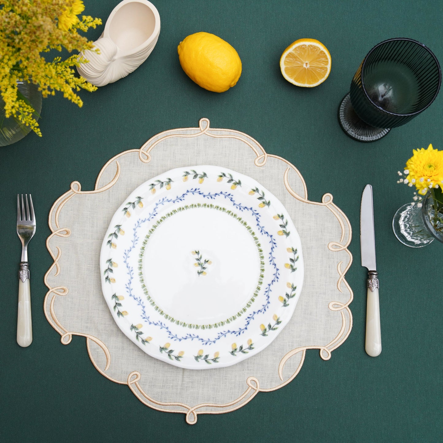 Gold-edged ivory fabric placemat arranged for formal dining