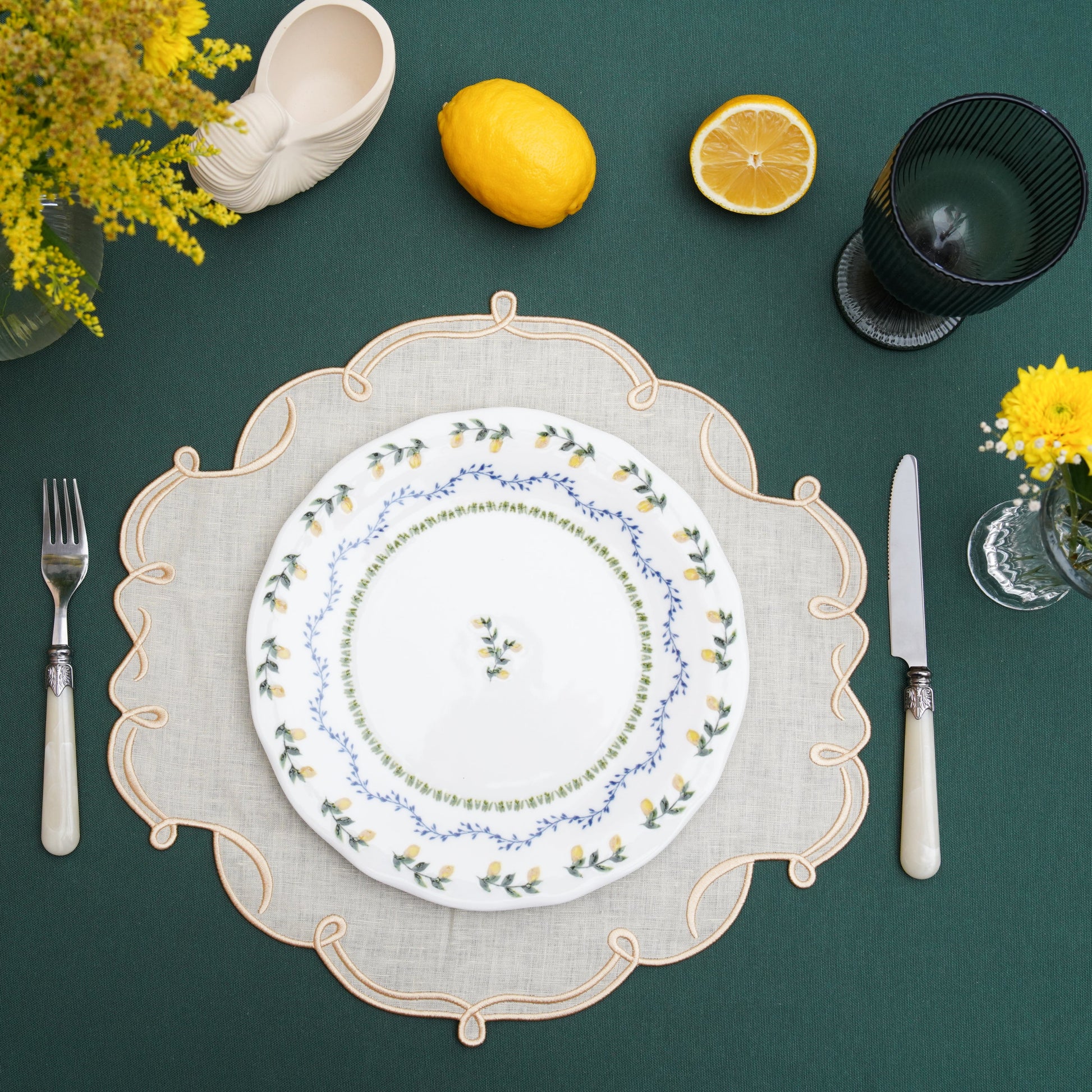 Gold-edged ivory fabric placemat arranged for formal dining